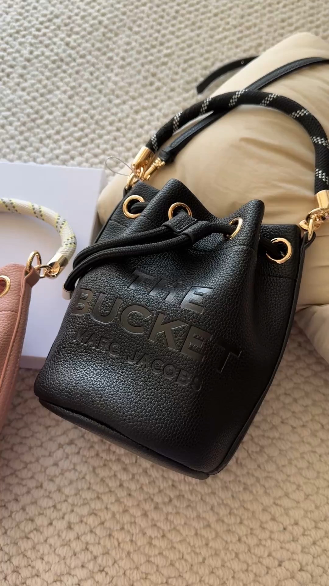 The body of the handbag features an embossed brand logo - Bag