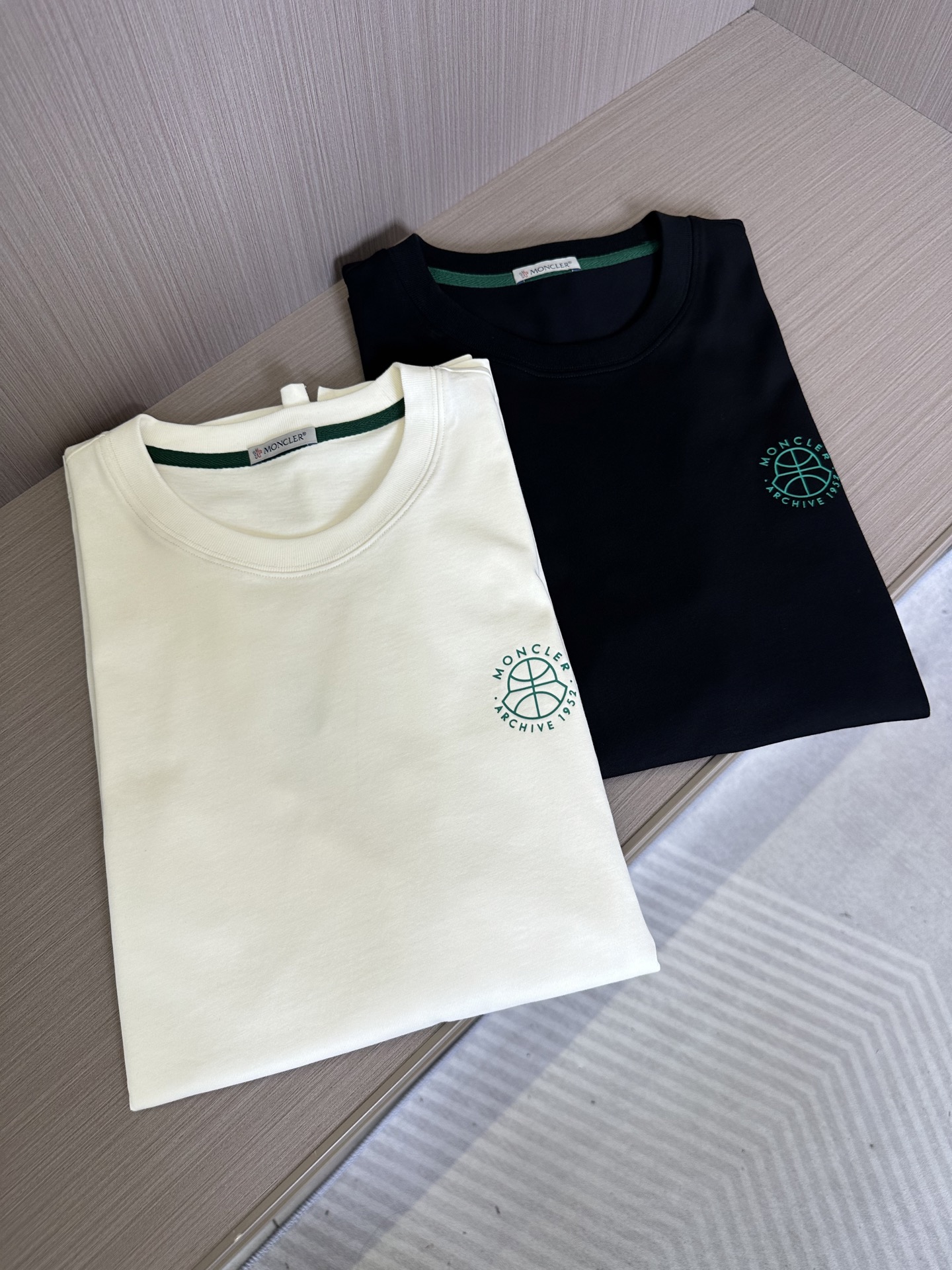 NO:130682,Mon family men's fashion round neck short-sleeved T-shirt, a new product in spring and summer for 25 years, a very popular single product!  A T-shirt that is very consistent with the aesthetic tone of M Home. The style design perfectly follows the essence of M Home. The chest is decorated with the new brand LOGO pattern of the season, and the personalized symmetrical inverted handstand pressing process design is full of three-dimensionality. It is equipped with a sleeve green wool felt brand badge logo, which is highly recognizable, showing a sense of high quality and fashion accent!  Customers supply top-quality fabrics imported from Egypt, selected high-quality cotton raw materials in the Nile area, and were made by Italian century-old workshops. They have a lot of cotton feel, both comfort and breathability, extremely delicate touch, and excellent skin-friendly!  The details are excellent, rigorous and detailed, the color scheme is simple, versatile and atmospheric, the upper body has first-class effect, fashionable and elegant, and full of temperament. It is quite outstanding in both inner wear and single wear. It can be controlled by business breathable and casual on the street!  Color black off-white Size 48-56, T-shirt,tees,t-shirt,alexander wang19860909Mon家族男士时装款圆领短袖T恤,25年春夏新品,超火爆人气单品！ 极符合M家美学基调的一款T恤,造型设计画风完美沿袭了M家的精髓,胸前饰有当季全新品牌LOGO图案,个性化对称倒立压胶工艺设计,立体感十足,搭载袖臂绿色羊毛毡品牌徽章标识,搭辨识度极高,彰显出高级感与时装的腔调！ 客供埃及进口顶级面料,甄选尼罗河区域光照极好的上等棉花原料,经过意大利百年工坊定织定染而成,棉感十足,舒适性与透气性兼备,触感极为细腻,亲肤性绝佳！ 细节处理非常出色,严谨而细致,配色简约百搭大气,上身效果一流,时髦且优雅,气质感十足,无论内搭还是单穿都颇为出彩,商务透气与出街休闲即可驾驭！ 颜色黑色 米白色 尺码48-56,,T-shirt,tees，t-shirt,alexander wang,Men's clothing