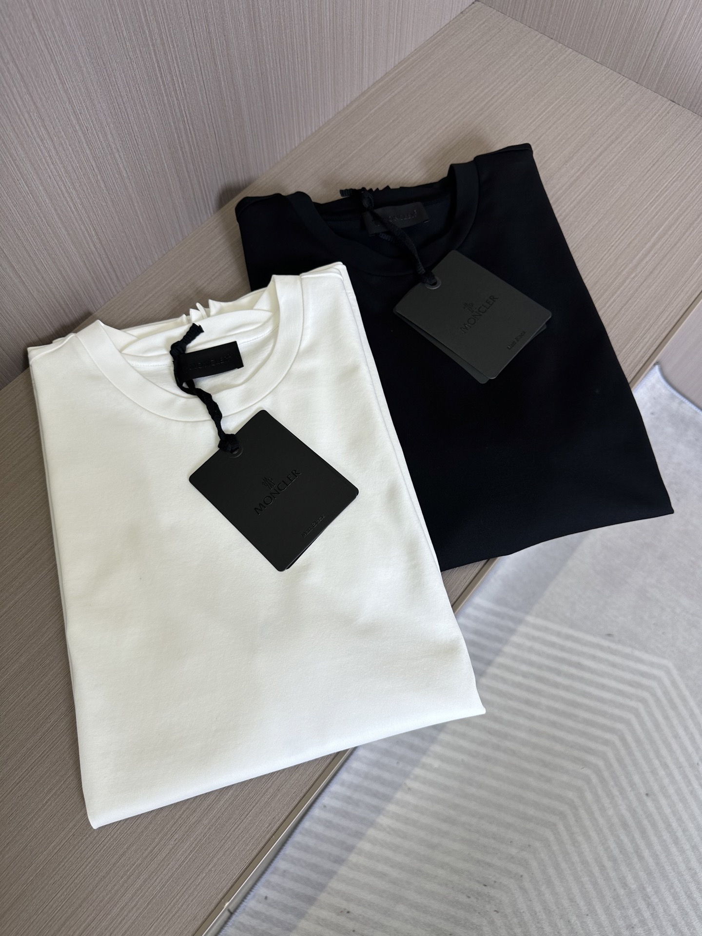 NO:130676,. MONCLER2025ss black label series short T  The fabric is made of 32 double-strand Xinjiang long velvet cotton tight round neck short Tee. This T-shirt is slightly wide-shaped, showing the charm of simplicity. The exquisite silicone black label with the armband, the contrasting color of the back color is inline for silicone logo. The neckline is not only made of wash-resistant and anti-loose, but also made the latest petal-type breaking design on the back collar. The fabric is the preferred raw material for high-end textiles in the world, and is called 