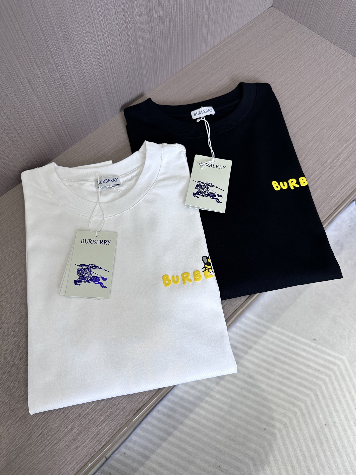 NO:131741,BU25SS spring and summer new jersey cotton round neck short Tee, men and women same bee pattern foam printed casual short-sleeved T-shirt!  Trading companies have sparse channels and are released on the official website at the same time!  Wearing this bee-patterned T-shirt, it seems like turning into an elf in nature, dancing with everything, enjoying freedom and comfort!  This T-shirt is made of custom jersey cotton, which is soft to the touch, breathable and skin-friendly when worn, ensuring comfort and high-end feel!  The design on the chest is particularly unique, with a row of yellow letters vividly appearing on the clothes. These letters are not only bright in color, but also in sharp contrast with the overall tone of the clothes!  The huge bee pattern decoration on the back all adopt advanced three-dimensional foaming technology, making the pattern emerge from the plane, presenting a lifelike three-dimensional feeling!  The basic round neck style is not only suitable for all body shapes, but can easily control different styles of dressing, but also ensures the cleverness and harmony of the clothes through the right tailoring and sewing process!  Whether worn alone or as an inner wear, it can show the wearer's fashion taste and unique temperament!  Black/white, two colors into it!  Size S-XXL S S shoulder width 45cm-bust 102cm-length 68cm M S shoulder width 46cm-bust 106cm-length 70cm L S shoulder width 47cm-bust 110cm-length 72cm XL S shoulder width 48cm-bust 114cm-length 74cm XXL S shoulder width 50cm-bust 118cm-length 76cm Size recommended (standard version) Height 174-140 catties, try on M size appropriately!  A boy can choose S code within 130 catties, a M code for 130-143 catties, a L code for 143-156 catties, a XL code for 156-170 catties, and a XXL code for 170-185 catties!  All girls can choose S code!  ,T-shirt,tees,t-shirt,alexander wang19860909BU25SS春夏新款平纹针织棉布圆领短Tee,男女同款蜜蜂图案发泡印花休闲短袖T恤衫！贸易公司渠道稀出,同步官网发售！穿上这件蜜蜂图案T恤,仿佛化身成为自然界中的一位精灵,与万物共舞,享受着自由与惬意！ 这款T恤选用客供定制平纹针织棉布,触感柔软,穿着时既透气又亲肤,确保了穿着的舒适性与高级感！胸前的设计尤为别致,一排黄色的字母标识跃然衣上,这些字母不仅颜色鲜亮,与衣身的整体色调形成了鲜明的对比！后幅硕大的蜜蜂图案装饰,均采用了先进的立体发泡工艺,使得图案从平面上跃然而出,呈现出一种栩栩如生的立体感！基础圆领版型,不仅适合各种身材,能够轻松驾驭不同的穿搭风格,更通过恰到好处的剪裁与缝制工艺,确保了衣物的挺括与合体！无论是单穿还是作为内搭,都能展现出穿着者的时尚品味与独特气质！黑色/白色,两色入！尺码S-XXL S码肩宽45cm-胸围102cm-衣长68cm M码肩宽46cm-胸围106cm-衣长70cm L码肩宽47cm-胸围110cm-衣长72cm XL码肩宽48cm-胸围114cm-衣长74cm XXL码肩宽50cm-胸围118cm-衣长76cm 尺码推荐（标准版型） 身高174-140斤,试穿M码合适！ 男生体重130斤以内选择S码,130-143斤选择M码,143-156斤选择L码,156-170斤选择XL码,170-185斤选择XXL码！ 女生全部选择S码即可！,,T-shirt,tees，t-shirt,alexander wang,Men's clothing