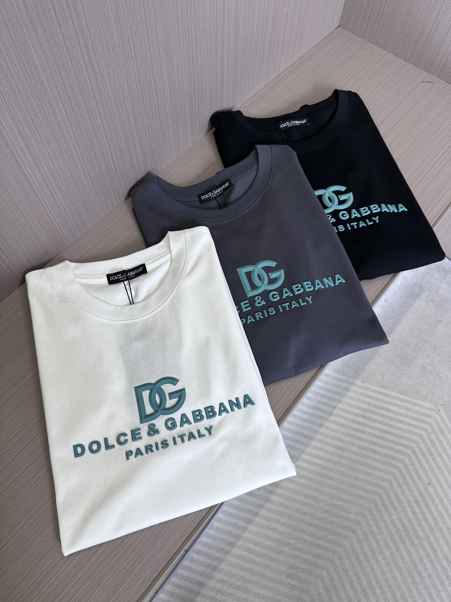 NO:441736,DG25SS spring and summer new knitted pure cotton casual round neck short T three-dimensional offset logo basic pullover short-sleeved T-shirt!  Leading official website release!  A heavy short Tee that combines fashion and texture, from the selection of fabrics to the processing of design details, reveals the brand's ultimate pursuit of quality and keen insight into trends!  This T-shirt is made of customized knitted cotton fabric for customer, which feels soft and comfortable to touch and is breathable. Even when worn in hot summer, it can be kept dry and not stuffy!  More importantly, it has good elasticity and wear resistance, can fit the body well, showing the wearer's confidence and style!  In terms of design, it is even more ingenious!  The three-dimensional rubber letter logo on the front is the finishing touch of this T-shirt!  These letter logos not only have smooth lines and clear outlines, but also through advanced three-dimensional offset printing technology, the letters seem to 'lead out' from the fabric, full of three-dimensionality and layering!  The casual straight round neck design is not only simple and elegant, easy to match, but also can well modify the body lines, making the wearer look more upright and stylish!  Black/white/gray, three colors into it!  Size S-XXL S S shoulder width 46cm-bust 104cm-length 66cm M S shoulder width 49cm-bust 110cm-length 68cm L S shoulder width 52cm-bust 116cm-length 70cm XL S shoulder width 55cm-bust 121cm-length 72cm XXL S shoulder width 57cm-bust 126cm-length 74cm Size recommendation (standard version) Height 174-140 catties, try on M size appropriately!  A boy can choose S code within 130 catties, a M code for 130-145 catties, a L code for 145-160 catties, a XL code for 160-175 catties, and a XXL code for 175-190 catties!  ,T-shirt,tees,t-shirt,alexander wang19860909DG25SS春夏新款针织纯棉休闲圆领短T 立体胶印标识基础套头短袖T恤衫！领先官网发售！一件集时尚与质感于一身的重磅短Tee,从面料的选择到设计细节的处理,都透露出品牌对品质的极致追求和对潮流的敏锐洞察！ 这款T恤采用客供定制针织纯棉面料,触感柔软舒适,透气性也极佳,即使在炎炎夏日穿着,也能保持干爽不闷热！更重要的是它具有良好的弹性和耐磨性,能够很好地贴合身形,展现出穿着者的自信与风采！设计方面,更是独具匠心！前幅的立体橡胶字母标识,是这款T恤的点睛之笔！这些字母标识不仅线条流畅、轮廓分明,而且通过先进的立体胶印技术,使得字母仿佛从面料中“跃然而出”,充满了立体感和层次感！休闲直筒圆领设计,不仅简约大方、易于搭配,而且能够很好地修饰身形线条,让穿着者看起来更加挺拔有型！黑色/白色/灰色,三色入！尺码S-XXL S码肩宽46cm-胸围104cm-衣长66cm M码肩宽49cm-胸围110cm-衣长68cm L码肩宽52cm-胸围116cm-衣长70cm XL码肩宽55cm-胸围121cm-衣长72cm XXL码肩宽57cm-胸围126cm-衣长74cm 尺码推荐（标准版型） 身高174-140斤,试穿M码合适！ 男生体重130斤以内选择S码,130-145斤选择M码,145-160斤选择L码,160-175斤选择XL码,175-190斤选择XXL码！,,T-shirt,tees，t-shirt,alexander wang,Men's clothing