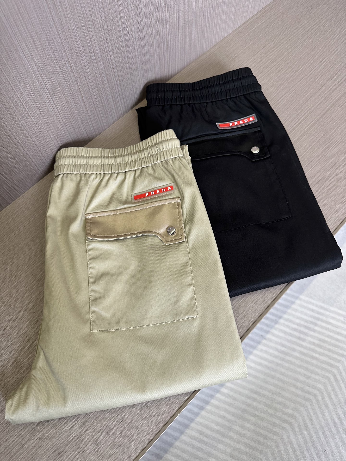 NO:146158,PRA25SS spring and summer new light twill fabric drawstring casual pants, men's red label interfacing bag basic versatile casual pants!  Trading companies have sparse channels and are on sale on the leading official website!  A fashionable item designed for you who value both quality and comfort. From the selection of fabrics to the carving of details, each part reveals ingenuity and high-end texture!  The trousers are made of customized thin twill fabrics, which not only feels silky, but also feels like a gentle breeze blowing across the skin, but also shiny, and can show charming brilliance in the sun!  At the same time, it also has excellent comfort and breathability, and even in the hot summer, it can make you feel as comfortable and comfortable as the spring breeze!  The front and rear pockets are uniquely spliced. This design not only breaks the monotony and mediocrity of traditional casual pants, but also gives the pants more layering and three-dimensionality!  What’s more clever is that the pocket is decorated with a red nameplate, showing extraordinary identity and taste!  Of course, as a casual pants, comfort is also crucial!  It adopts a drawstring elastic waist design. This design is not only easy to put on and take off, but also freely adjusts the tightness according to your waistline, ensuring that you can enjoy the most comfortable wearing experience at any time!  The casual straight-tube style can well modify the leg shape. Whether it is matched with sports shoes or casual shoes, it can be easily controlled, showing a casual and fashionable attitude!  Black/khaki, two colors into it!  Size M-3XL M size waist 74/80cm-hip circumference 96cm-front 28cm-thigh circumference 58cm-trouser length 100cm-trouser legs 34cm L size waist 78/84cm-thigh circumference 100cm-front 29cm-thigh circumference 60cm-trouser length 101cm-trouser legs 35cm XL size waist 82/88cm-thigh circumference 104cm-front 30cm-thigh circumference 62cm-trouser length 102cm-trouser legs 36cm XXL size waist 86/92cm-thigh circumference 108cm-front 31cm-thigh circumference 64cm-trouser length 103cm-trouser legs 37cm  3XL size waist circumference 90/96cm - hip circumference 112cm - front gear 31cm - thigh circumference 66cm - trouser length 103cm - trouser legs 38cm recommended size (standard version) Height 174-140 catties, try on size L appropriately!  A boy can choose M code within 130 catties, a L code for 130-143 catties, a XL code for 143-156 catties, a XXL code for 156-170 catties, and a 3XL code for 170-186 catties!  , prada,sneakers,alexander wang19860909PRA25SS春夏新款轻薄斜纹面料抽绳休闲裤,男士红标拼接口袋基础百搭休闲长裤！贸易公司渠道稀出,领先官网发售！一款专为追求品质与舒适并重的你而设计的时尚单品,从面料的选择到细节的雕琢,每一处都透露着匠心独运与高端质感！ 该裤装采用了客供定制轻薄斜纹面料,不仅触感丝滑,仿佛轻柔的微风拂过肌肤,还富有光泽,能够在阳光下展现出迷人的光彩！同时它还具有出色的舒爽透气性,即使在炎炎夏日,也能让你感受到如沐春风般的自在与惬意！前后口袋均采用了独特的拼接设计,这种设计不仅打破了传统休闲裤的单调与平庸,还赋予了裤子更多的层次感和立体感！更为巧妙的是口袋上还搭配了红色的铭牌点缀,展现出不凡的身份与品味！ 当然作为一款休闲裤,舒适度也是至关重要的！它采用了抽绳松紧裤腰设计,这种设计不仅方便穿脱,还能根据你的腰围自由调节松紧度,确保你在任何时刻都能享受到最舒适的穿着体验！而休闲直筒的版型则能够很好地修饰腿型,无论是搭配运动鞋还是休闲鞋,都能轻松驾驭,展现出随性自在的时尚态度！黑色/卡其,两色入！尺码M-3XL M码腰围74/80cm-臀围96cm-前档28cm-大腿围58cm-裤长100cm-裤脚34cm L码腰围78/84cm-臀围100cm-前档29cm-大腿围60cm-裤长101cm-裤脚35cm XL码腰围82/88cm-臀围104cm-前档30cm-大腿围62cm-裤长102cm-裤脚36cm XXL码腰围86/92cm-臀围108cm-前档31cm-大腿围64cm-裤长103cm-裤脚37cm 3XL码腰围90/96cm-臀围112cm-前档31cm-大腿围66cm-裤长103cm-裤脚38cm 尺码推荐（标准版型） 身高174-140斤,试穿L码合适！ 男生体重130斤以内选择M码,130-143斤选择L码,143-156斤选择XL码,156-170斤选择XXL码,170-186斤选择3XL码！,,prada,sneakers,alexander wang,Men's clothing