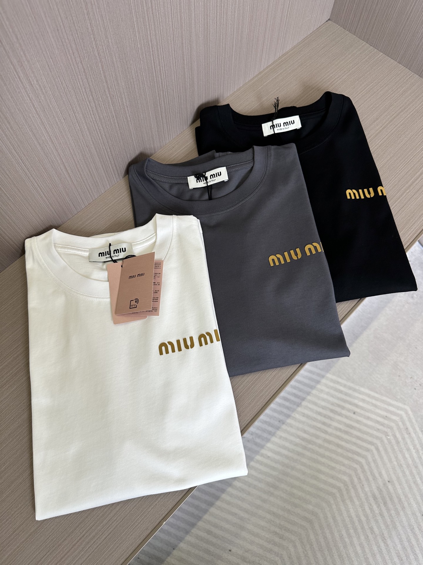 NO:155796,MIU25SS spring and summer new jersey cotton basic round neck short Tee, men and women's three-dimensional letter logo offset printing casual straight short-sleeved MIU new T-shirts from the choice of fabric to the details of design, all reveal the brand's ultimate pursuit of quality and unique insights into fashion!  The short Tee uses customized jersey fabrics for customer supply. It not only feels soft and comfortable to touch, but also has good breathability and moisture absorption. It can keep the skin dry and comfortable even in the hot summer!  The classic letter logo on the chest adopts a three-dimensional hot-pressing and offset printing process. This process not only makes the logo look more three-dimensional and full, layered, but also smoother in the touch, not easy to fall off or crack, ensuring the coexistence of the fashion sense and durability of the T-shirt!  The simple but fashionable logo design not only shows the unique tone of the Miu brand, but also inadvertently reveals the wearer's taste and style!  The basic straight round neck style is not only versatile but not picky, but can be easily controlled whether it is paired with jeans, casual pants or skirts, showing different styles and charm!  Black/white/gray, three colors into it!  Size S-XXL S S shoulder width 46cm-bust 102cm-length 66cm M S shoulder width 49cm-bust 108cm-length 68cm L S shoulder width 52cm-bust 114cm-length 70cm XL S shoulder width 55cm-bust 119cm-length 72cm XXL S shoulder width 57cm-bust 124cm-length 74cm Size recommendation (standard version) Height 174-catties, try on M size appropriately!  A boy can choose S code within 130 catties, a M code for 130-143 catties, a L code for 143-156 catties, a XL code for 156-170 catties, and a XXL code for 170-186 catties!  ,miumiu,skirts,jeans,T-shirt,tees,t-shirt,alexander wang19860909MIU25SS春夏新款平纹针织棉布基础圆领短Tee,男女同款立体字母标识胶印休闲直筒短袖MIU新款T恤从面料的选择到设计的细节,都透露着品牌对品质的极致追求与对时尚的独到见解！ 该短Tee采用了客供定制平纹针织面料,不仅触感柔软舒适,还具有良好的透气性和吸湿性,即便在炎炎夏日也能保持肌肤的干爽与自在！胸前的经典字母标识Logo,采用了立体热压胶印工艺,这种工艺不仅让Logo看起来更加立体饱满,富有层次感,而且在触感上也更加平滑,不易脱落或开裂,确保了T恤的时尚感与耐用性并存！简约而不失时髦的Logo设计,不仅展现了Miu品牌的独特调性,更在不经意间透露出穿着者的品味与格调！基础直筒圆领版型,不仅百搭不挑人,无论是搭配牛仔裤、休闲裤还是半身裙,都能轻松驾驭,展现出不同的风格魅力！黑色/白色/灰色,三色入！尺码S-XXL S码肩宽46cm-胸围102cm-衣长66cm M码肩宽49cm-胸围108cm-衣长68cm L码肩宽52cm-胸围114cm-衣长70cm XL码肩宽55cm-胸围119cm-衣长72cm XXL码肩宽57cm-胸围124cm-衣长74cm 尺码推荐（标准版型） 身高174-斤,试穿M码合适！ 男生体重130斤以内选择S码,130-143斤选择M码,143-156斤选择L码,156-170斤选择XL码,170-186斤选择XXL码！,,miumiu,skirts,jeans,T-shirt,tees，t-shirt,alexander wang,Men's clothing