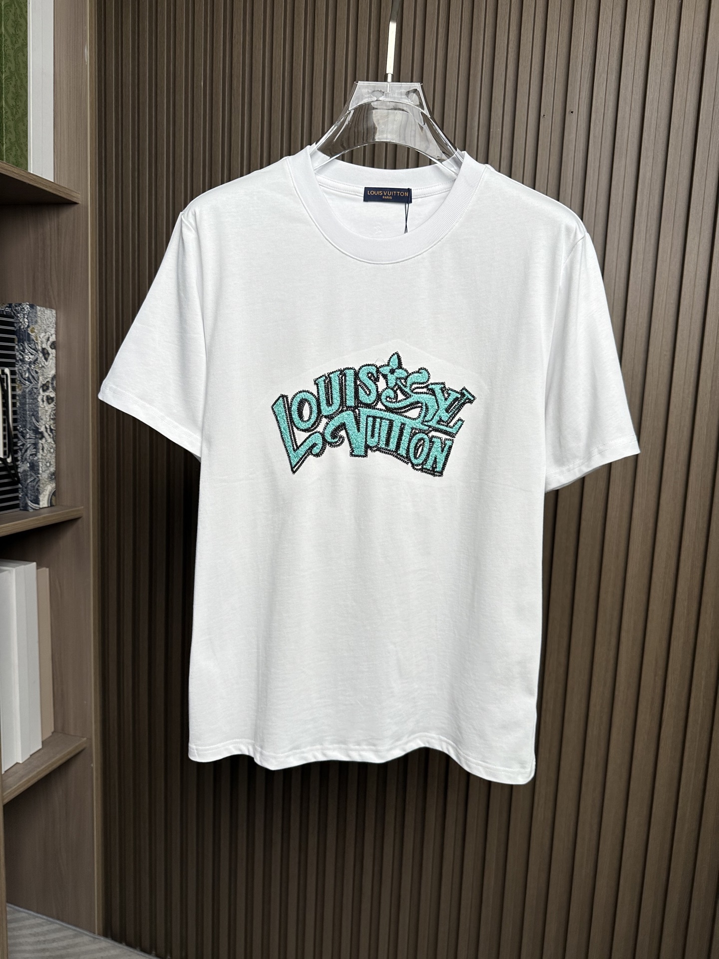 NO:912504,(White ~) LV Lujia 26SS new spring and summer plain knitted cotton basic round neck short T-shirt, heavy industry graffiti letter logo embroidery casual pullover short-sleeved T-shirt!  On sale simultaneously on the official website!  A fashion masterpiece that combines artistic inspiration and exquisite craftsmanship. It is not only a piece of clothing, but also a symbol of a life attitude, a pursuit of freedom, individuality and art!  This T-shirt is made of custom-made plain knitted cotton fabric. The fabric feels comfortable and delicate, and has good breathability. Even in the hot summer, you will not feel stuffy when wearing it. It is like covering your body with a layer of breathable gauze, keeping you dry and comfortable at all times!  The turquoise letter Logo on the front is like a sparkling gem in the night sky, exuding a mysterious and charming light!  The designer cleverly integrated the elements of street graffiti into the letter logo. Every line seems to be the strokes of a street artist, full of movement and vitality!  The heavy dense needle embroidery process is the soul of this T-shirt!  The hard work and sweat of the craftsmen have been poured into every stitch and thread. They use exquisite skills to perfectly present the letter logo on the fabric. The embroidery stitches are delicate and even, the lines are smooth and natural, as if a beautiful picture is slowly unfolding on the fabric!  The fitted version design can perfectly fit the curves of the body and show the wearer's figure advantages. Whether it is the line of the shoulders, the tightening of the waist or the treatment of the cuffs, they are all just right, comfortable and beautiful!  Color white, black Size S-XXL Size reference S size shoulder width 45 bust 104 length 67 M size shoulder width 46 bust 108 length 68 L size shoulder width 47 bust 112 length 69 XL size shoulder width 48 bust 116 length 70 2XL size shoulder width 49 bust 120 length 71  vuitton,T-shirt,tees,t-shirt,19860909（白色～）LV驴家26SS春夏新款平纹针织棉布基础圆领短T,重工涂鸦字母标识刺绣休闲套头短袖T恤衫！同步官网发售！一件融合了艺术灵感与精湛工艺的时尚杰作,它不仅仅是一件衣服,更是一种生活态度的象征,一种对自由、个性和艺术的追求！ 这款T恤采用客供定制平纹针织棉布,面料手感舒适细腻,同时具有良好的透气性,即使在炎炎夏日,穿上它也不会感到闷热,就像给身体披上了一层会呼吸的轻纱,时刻保持着干爽与自在！前幅绿松石色字母Logo宛如夜空中闪烁的宝石,散发着神秘而迷人的光芒！设计师巧妙地将街头涂鸦的元素融入到字母Logo中,每一个线条都仿佛是街头艺术家挥洒的笔触,充满了动感与活力！而重工密针刺绣工艺,则是这款T恤的灵魂所在！每一针每一线都倾注了工匠们的心血和汗水,他们用精湛的技艺将字母Logo完美地呈现在面料上,刺绣的针法细腻而均匀,线条流畅而自然,仿佛是一幅精美的画卷在面料上徐徐展开！合身版型设计,能够完美地贴合身体的曲线,展现出穿着者的身材优势,无论是肩部的线条、腰部的收束还是袖口的处理,都恰到好处,既舒适又美观！ 颜色白色、黑色 尺码S-XXL 尺寸参考 S码肩宽45胸围104衣长67 M码肩宽46胸围108衣长68 L码肩宽47胸围112衣长69 XL码肩宽48胸围116衣长70 2XL码肩宽49胸围120衣长71,,louis vuitton,louis vuitton,louis vuitton,T-shirt,tees，t-shirt,,Men's clothing