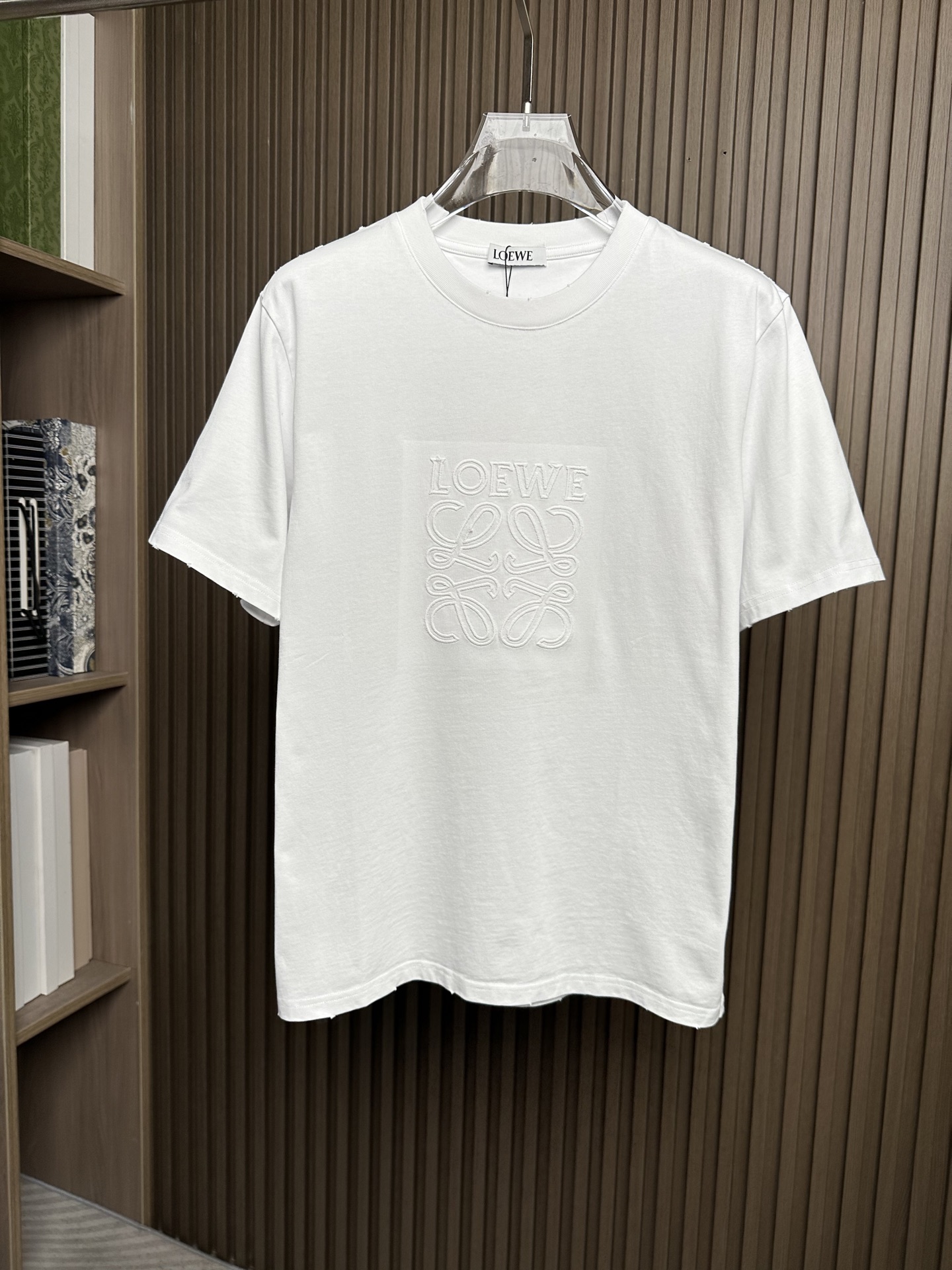 NO:912507,(White ~) LOE Loewe 26SS new spring and summer plain knitted cotton basic round neck short T-shirt, casual short-sleeved T-shirt with three-dimensional logo pattern embroidery!  On sale simultaneously on the official website!  In the vast world of fashion, there are always some items that can stand out with their unique design and excellent quality and become the focus of everyone's attention. LW badge embroidered T-shirt is one of them!  This T-shirt is made of custom-made jersey cotton. The fabric feels soft and delicate, as if clouds are caressing your skin, bringing you an unparalleled comfort experience!  And it has good breathability, allowing the skin to breathe freely, keep it dry, and stay away from the troubles of stuffiness and stickiness even in the hot summer!  The three-dimensional logo pattern embroidery in the same color on the front panel is not a simple decoration, but a masterpiece of the designer's ingenuity!  The embroidery craftsmanship is exquisite, every stitch and every thread is precise, perfectly presenting the outline and details of the logo!  The matching of the same color makes the embroidery and fabric blend into one, which is not too ostentatious and obtrusive, but can also inadvertently show a low-key sense of luxury and high-end!  The frayed details on the edges of the body add a unique fashion charm to this T-shirt!  The designer cleverly uses fraying technology to create a natural and casual fraying effect on the edges of the body. This kind of detail processing not only creates a strong sense of fashion, but also makes the entire T-shirt more personalized and layered, making you stand out from the crowd!  The fitted design can perfectly fit the curves of the body. It is neither too tight to restrict your movements nor too loose to make you look bulky and dragging!  It can subtly modify your figure, show off your advantages, and at the same time cleverly cover up some minor flaws!  Color White, Black Size S-XXL Size Reference S Size Shoulder Width 44 Bust 98 Length 65 M Size Shoulder Width 45 Bust 102 Length 66 L Size Shoulder Width 46 Bust 106 Length 6719860909（白色～）LOE罗意威26SS春夏新款平纹针织棉布基础圆领短T,立体徽标图案刺绣休闲短袖T恤衫！同步官网发售！在时尚的广袤天地里,总有一些单品能够凭借独特的设计与卓越的品质脱颖而出,成为众人瞩目的焦点,LW徽章刺绣T恤便是其中之一！ 这款T恤采用客供定制平纹针织棉布,面料触感柔软细腻,仿佛云朵轻抚肌肤,带来无与伦比的舒适体验！而且它具有良好的透气性,即使在炎炎夏日,也能让肌肤自由呼吸,保持干爽,远离闷热与黏腻的困扰！前幅同色系立体徽标图案刺绣,这可不是简单的装饰,而是设计师匠心独运的杰作！刺绣工艺精湛绝伦,每一针每一线都精准无误,将徽标的轮廓与细节完美呈现！同色系的搭配使得刺绣与面料融为一体,既不会过于张扬突兀,又能在不经意间展现出低调的奢华与高级感！衣身边缘处的磨破细节处理,更是为这款T恤增添了一抹别样的时尚魅力！设计师巧妙地运用磨破工艺,在衣身边缘处打造出自然而随性的磨损效果,这种细节处理不仅营造出了强烈的时尚感,还让整件T恤更具个性与层次感,让你在人群中脱颖而出！合身版型设计,能够完美地贴合身体曲线,既不会过于紧绷束缚你的行动,也不会过于宽松显得臃肿拖沓！它能够巧妙地修饰身材,展现出你的优点,同时巧妙地掩盖一些小瑕疵！ 颜色白色、黑色 尺码S-XXL 尺寸参考 S码肩宽44胸围98衣长65 M码肩宽45胸围102衣长66 L码肩宽46胸围106衣长67 XL码肩宽47胸围衣长68 XXL码肩宽48胸围114衣长69,,loewe,loewe,T-shirt,tees，t-shirt,,Men's clothing