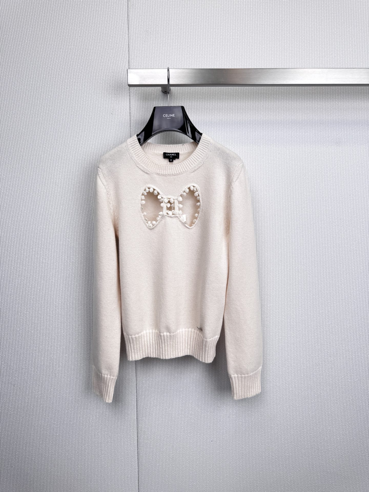 NO:591370,Chanel's hollow bow sweater interprets classics and defines elegance. It continues to write fashion legends with the brand's iconic off-white and dark black. The decoration on the chest is not an ordinary bow, but a three-dimensional hollow pattern transformed from the classic 'CC' logo, and decorated with lustrous pearl sequins.  Exquisite craftsmanship is shown in every detail. It is woven with soft velvet and matched with a simple ribbed round neck and cuffs to outline a calm and elegant silhouette, making it a timeless style item in the wardrobe. This decoration that looks like a bow is actually cleverly composed of the classic 'CC' logo!  With the embellishment of pearl sequins, the details are perfect and exquisite. The simple round neck design is versatile and practical. Whether it is paired with jeans or a skirt, it can instantly enhance the overall texture. Classic black and white two-color, which one will you pick?  Code number SML,,chanel,skirts,jeans,sweaters,alexander wang19860909Chanel镂空蝴蝶结毛衣,诠释经典,定义优雅,以品牌标志性的米白与玄黑,续写时尚传奇.胸前装饰并非寻常蝴蝶结,而是由经典“CC”徽标幻化而成的立体镂空图案,并缀以莹润珍珠亮片,于细节处尽显精湛工艺,甄选柔软绒线织就,搭配简约罗纹圆领与袖口,勾勒出从容自如的优雅轮廓,成就衣橱中永不过时的风格单品,这只看似蝴蝶结的装饰,其实是由经典的“CC”标志巧妙构成的！加上珍珠亮片的点缀,细节满分,精致到无可挑剔,简约的圆领设计,百搭实穿,无论是搭配牛仔裤还是半裙,都能瞬间提升整体质感.经典黑白双色,你会PICK哪一件？码数SML,,chanel,skirts,jeans,sweaters,alexander wang,Women's clothing