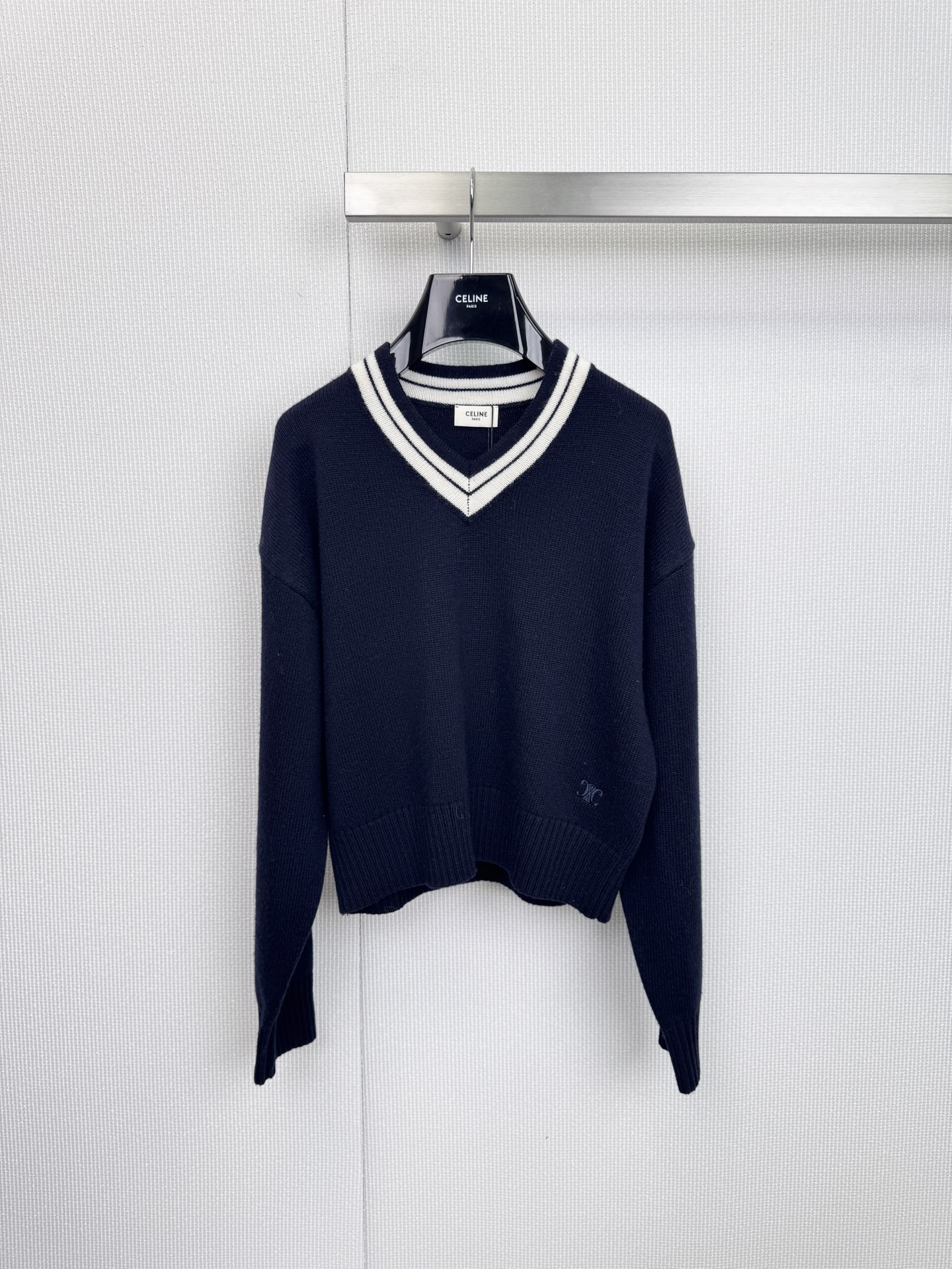 NO:628915,CELINE dark blue V-neck sweater is a dialogue between Italian weaving and Parisian aesthetics. It is made of pure wool and adopts precision rib knitting technology to create a light and warm three-dimensional silhouette. The dark blue base is paired with a college-style V-neck. Black thin lines are hidden in the white edge panels to enhance the visual hierarchy.  The embroidered logo on the hem continues the brand's concept of low-key luxury. The depth of the V-neck has been precisely calculated. It can be worn under a shirt to create a business casual style, or can be worn alone to highlight the clavicle line. The wool has been treated with anti-puncture treatment, and the next-to-skin surface presents a micro-velvety texture, which reduces the itch of traditional wool. The inner layer is white.  A poplin shirt is paired with gray trousers, and the collar is slightly exposed. The material contrast interprets the character of a modern gentleman. A silk suspender skirt is layered with Chelsea boots. A metal necklace is used to create a visual focus at the V-neck. This sweater injects the elegance of Paris’ Left Bank into the ingenuity of the Apennine Peninsula.  Fingertips pass over the delicate ribbed fabric, and every touch tells the eternal law of quality. Size SML, celine, boots, skirts, sweaters, shirts, necklace, real  silk,alexander wang19860909CELINE深蓝V领毛衣,意式织造与巴黎美学的对话,纯羊毛材质,采用精密罗纹针织工艺,打造轻盈保暖的立体廓形,深蓝色基底搭配学院风V领,白边嵌条中暗藏黑色细线提升视觉层次,下摆刺绣徽标延续品牌低调奢华理念,V领深度经过精密计算,既可内搭衫打造商务休闲风,亦能单穿凸显锁骨线条,羊毛经过抗扎处理,贴肤面呈现微绒质感,减少传统羊毛的刺痒感,内搭白色府绸衬衫搭配灰色西裤,领口微露材质对比诠释现代绅士品格,叠穿真丝吊带裙搭配切尔西靴,用金属项链在V领处制造视觉焦点,这件毛衣将巴黎左岸的优雅基因注入亚平宁半岛的匠心工艺,当指尖掠过细腻的罗纹织面,每一次触碰都在诉说关于品质的永恒定律.码数SML,,celine,boots,skirts,sweaters,shirts,necklace,real silk,alexander wang,Women's clothing