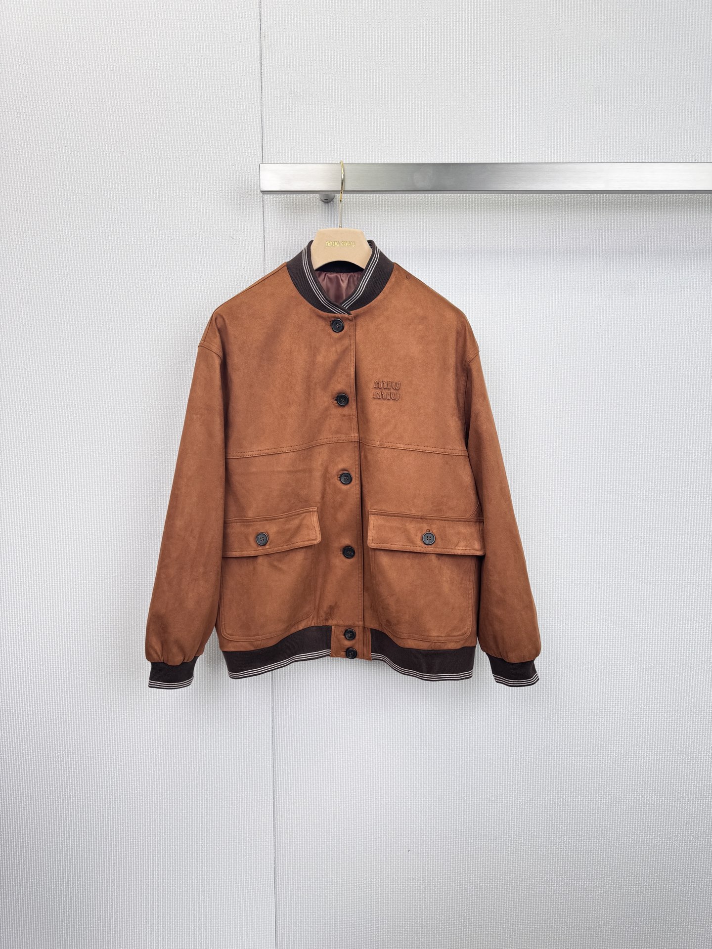 NO:628886,Miu Miu suede suit is retro and modern, interpreting low-key academic luxury. This series uses brown suede fabric with extraordinary texture to reshape classic academic style items, showing Miu in every detail.  Miu's unique sweetness and rebellious genes are made of suede fabric with a warm texture, mellow color and soft touch, highlighting a low-key sense of luxury. The lapel design is paired with dark brown trim and white stripes, with iconic black buttons on the front. The exquisite embroidered logo on the left chest is extraordinary in simplicity, and the well-fitting tailoring and matching  The well-proportioned breast pocket design and replica of the classic jacket style make it easy to match with a retro and fashionable look. The A-line pleated skirt style has neat and smooth pleats, which effectively modify the body lines and make walking full of smart rhythm. The upper and lower garments are made of suede of the same color and same quality, creating a harmonious and unified sense of high-end suits, eliminating the worry of matching. This Miu set  Miu suede suit is not only a tasteful addition to your wardrobe, but also a model that perfectly integrates retro sentiments with contemporary fashion. It is suitable for showing your unique fashion taste on a variety of occasions. ,,miumiu,skirts,jackets & coats,chamois leather,alexander wang19860909Miu Miu麂皮绒套装,复古摩登,诠释低调的学院派奢华,本系列以质感非凡的棕色麂皮绒面料,重塑经典学院风单品,于细节处展现Miu Miu独有的甜美与叛逆基因,采用质感温润的麂皮绒面料,色泽醇厚,触感柔软,彰显低调的奢华感,翻领设计搭配深棕色镶边与白色条纹,正面点缀标志性黑色纽扣,左胸的精致刺绣Logo,于简约中见不凡,合身的剪裁与对称的胸袋设计,复刻经典夹克款式,轻松搭配出复古又时髦的造型,A字百褶裙款式,褶皱利落流畅,有效修饰身材线条,行走间充满灵动韵律,上下装采用同色同质麂皮绒,营造出和谐统一的高级套装感,省去搭配烦恼,这套Miu Miu麂皮绒套装不仅是衣橱里的品位担当,更是将复古情怀与当代时尚完美融合的典范之作,适合在多种场合展现您独特的时尚品味. 上,,miumiu,skirts,jackets & coats,chamois leather,alexander wang,Women's clothing