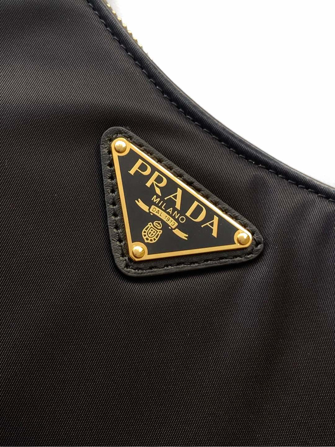 Prada 这款单肩包风格现代百搭 采用再生尼龙（Re-Nylon）材料制成 搭配 的皮革细节