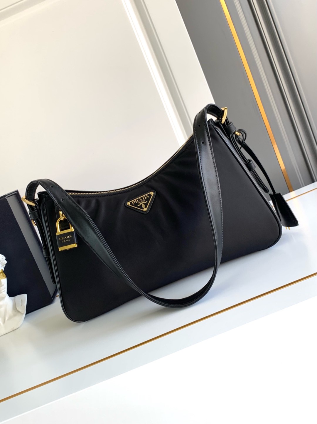 Prada 这款单肩包风格现代百搭 采用再生尼龙（Re-Nylon）材料制成 搭配 的皮革细节