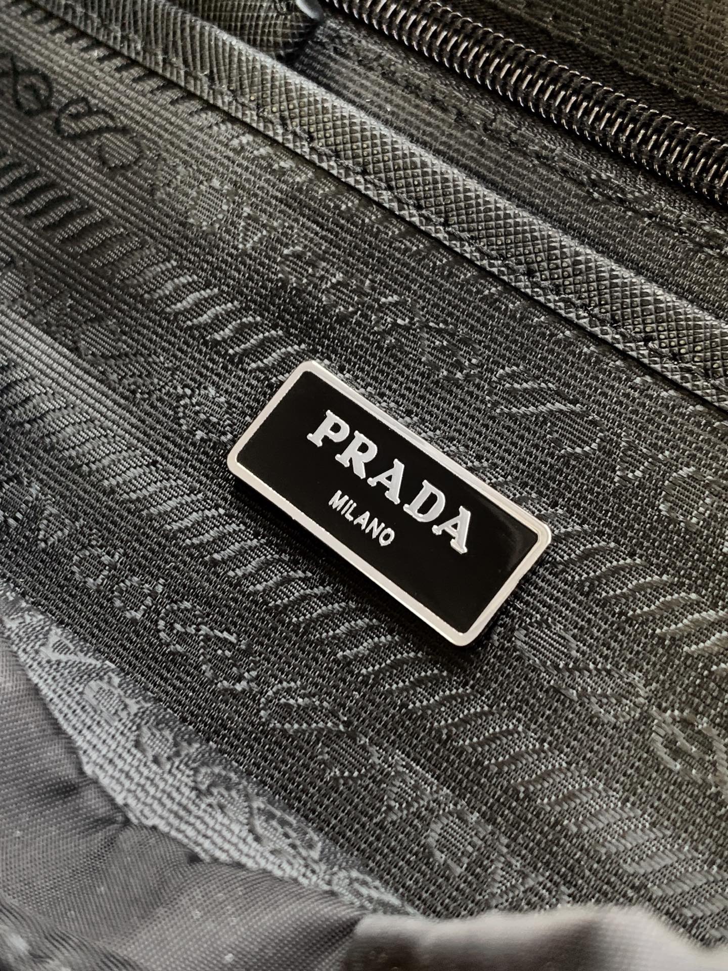 Prada 这款尼龙双肩包采用 Saffiano皮革饰边 融合多种材质 并饰有三角形徽标