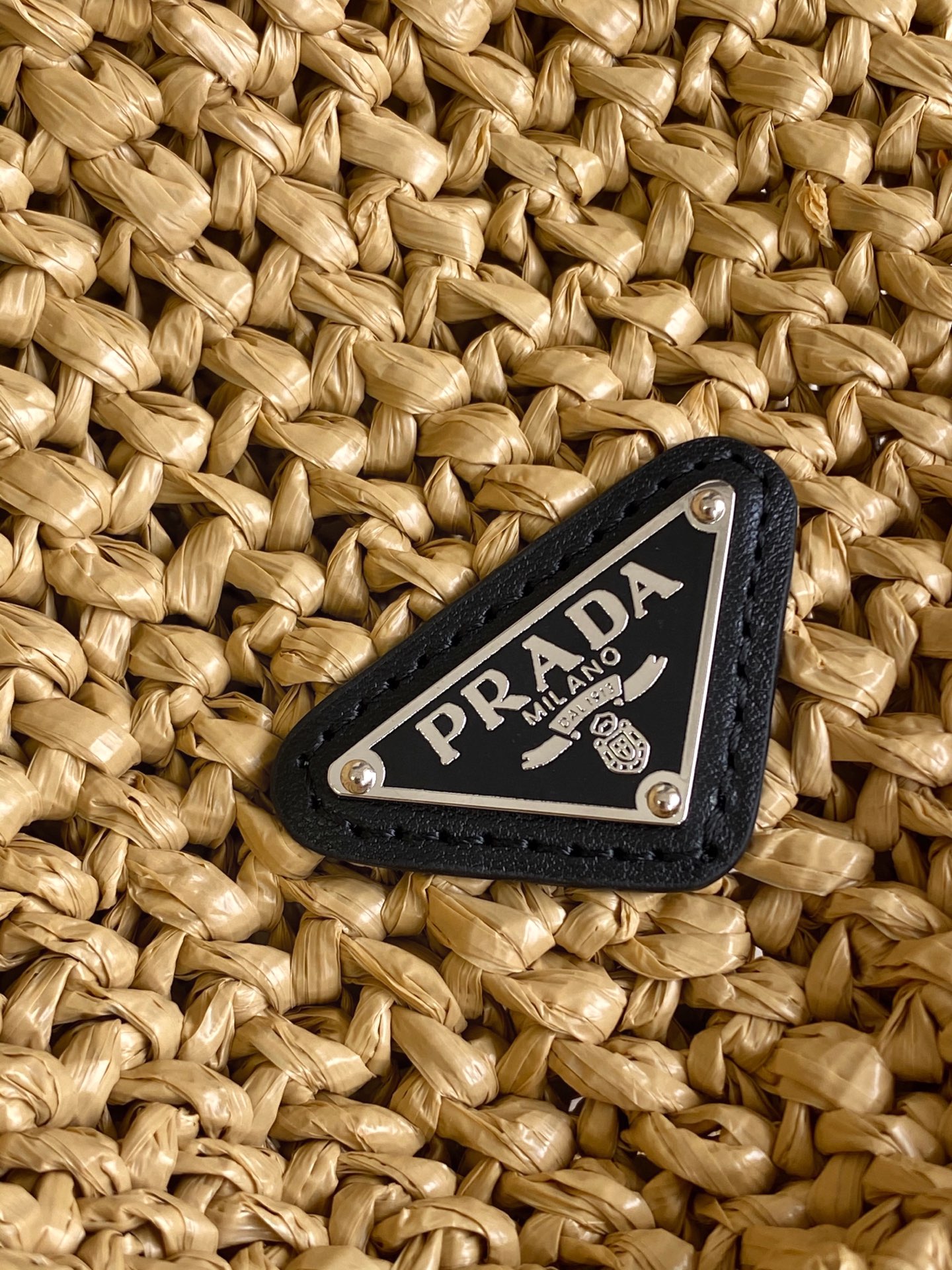 Prada 这款托特包采用洋溢夏日风情的轻质天然酒椰纤维打造 柔和的解构式设计赋予包身别样的现代魅力