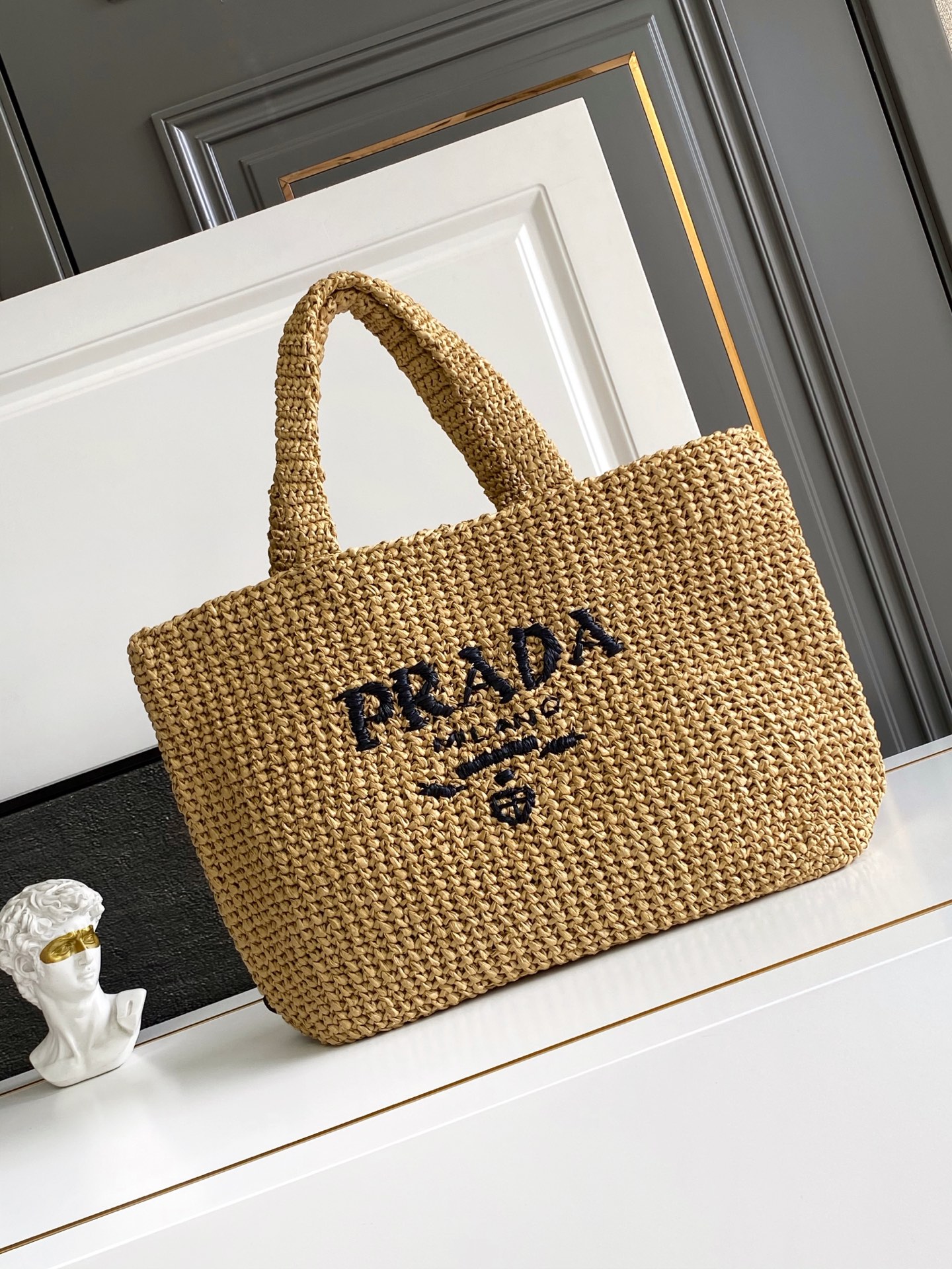 Prada 这款托特包采用洋溢夏日风情的轻质天然酒椰纤维打造 柔和的解构式设计赋予包身别样的现代魅力