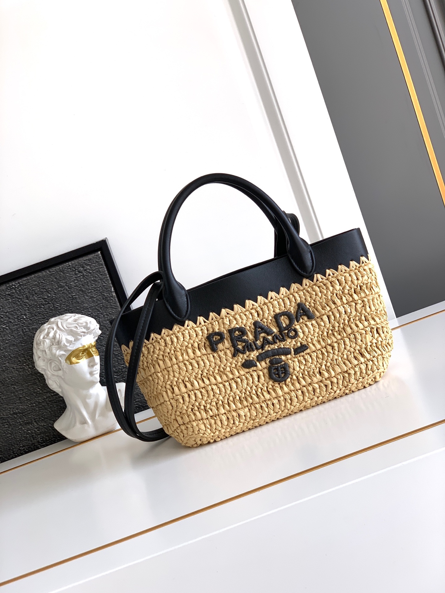 Prada 这款现代而 的迷你托特包结合钩编工艺和皮革细节 营造出夏日氛围 牛皮双提手