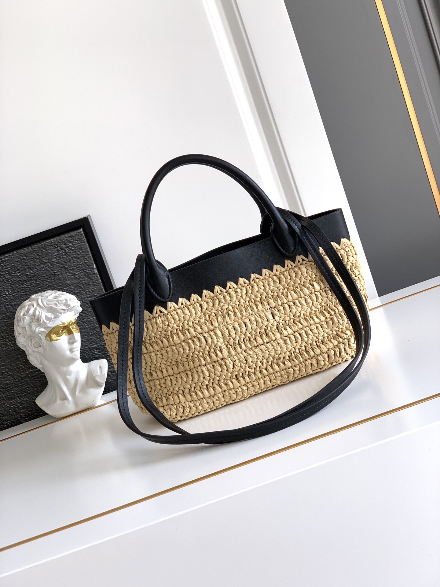 Prada 这款现代而 的迷你托特包结合钩编工艺和皮革细节 营造出夏日氛围 牛皮双提手