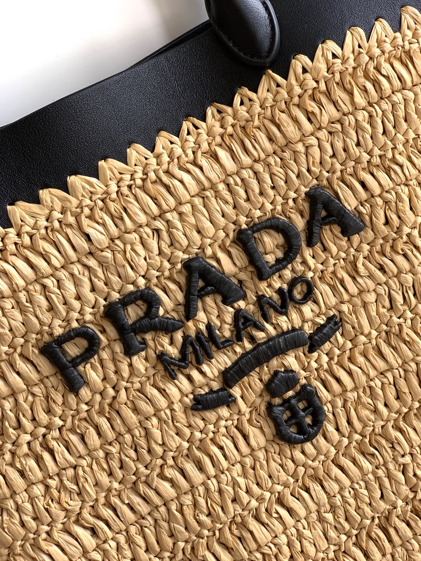 Prada 这款现代而 的迷你托特包结合钩编工艺和皮革细节 营造出夏日氛围 牛皮双提手