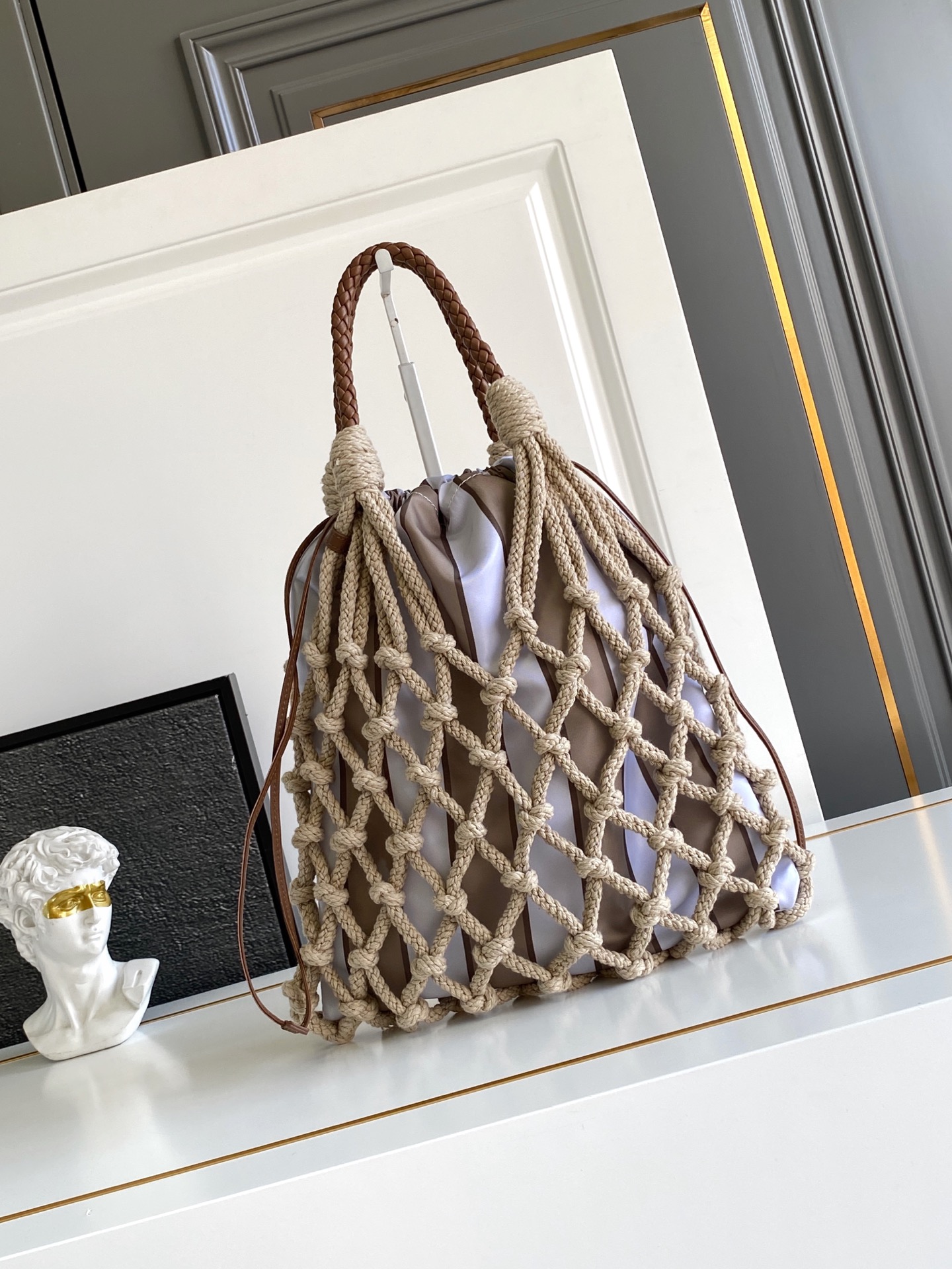 Bottega Veneta 航海世界启发了这款手工饰边手袋的花边设计 体现了清新素雅气质与真实的自由感