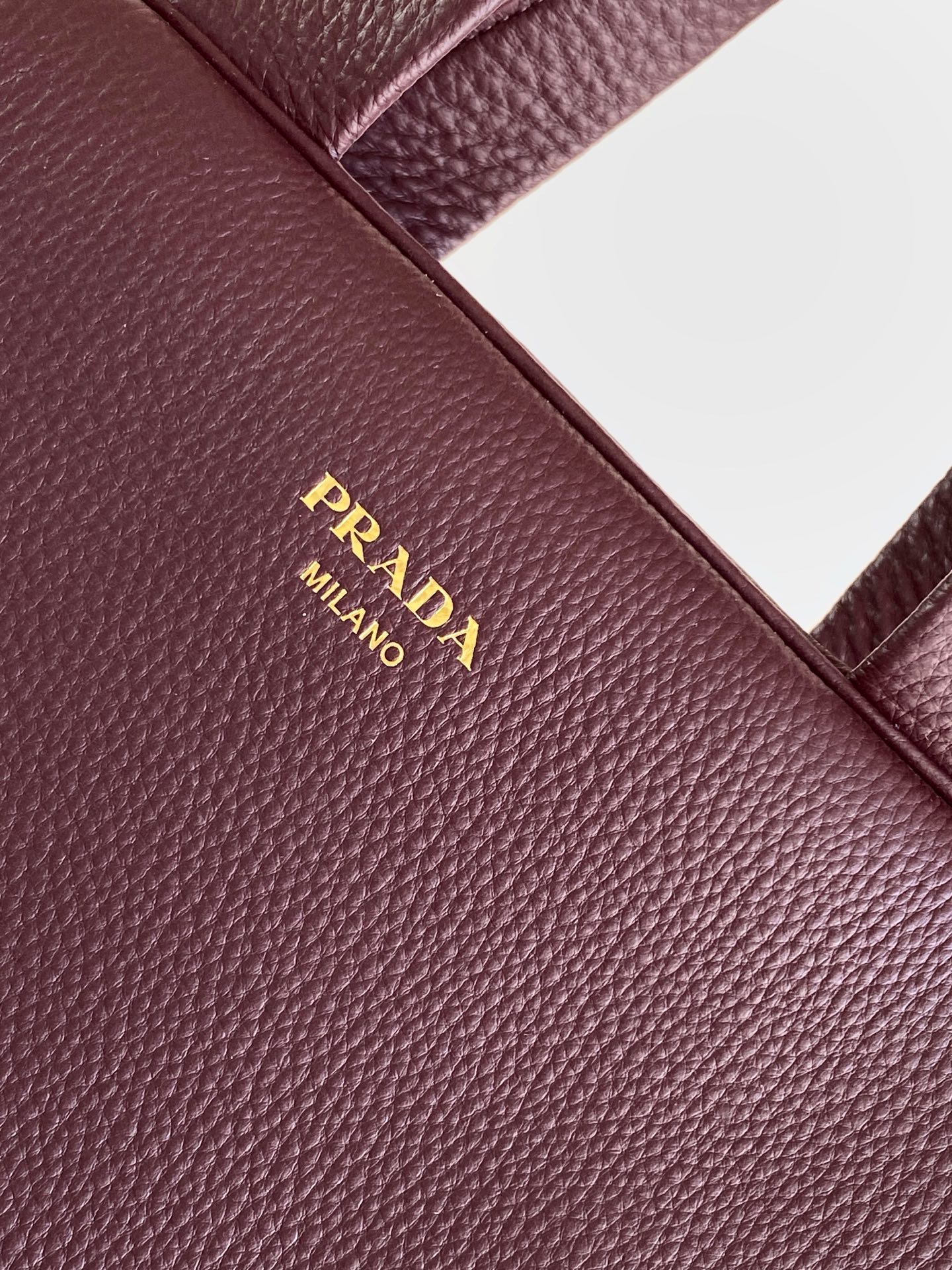 Prada 这款天然粒面皮革制成的顶部提手包袋以柔软的轮廓进行了重新诠释 可手提或搭配可拆式肩带佩戴