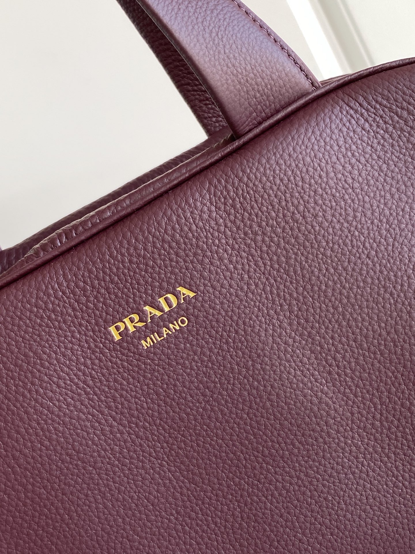Prada 这款天然粒面皮革制成的顶部提手包袋以柔软的轮廓进行了重新诠释 可手提或搭配可拆式肩带佩戴