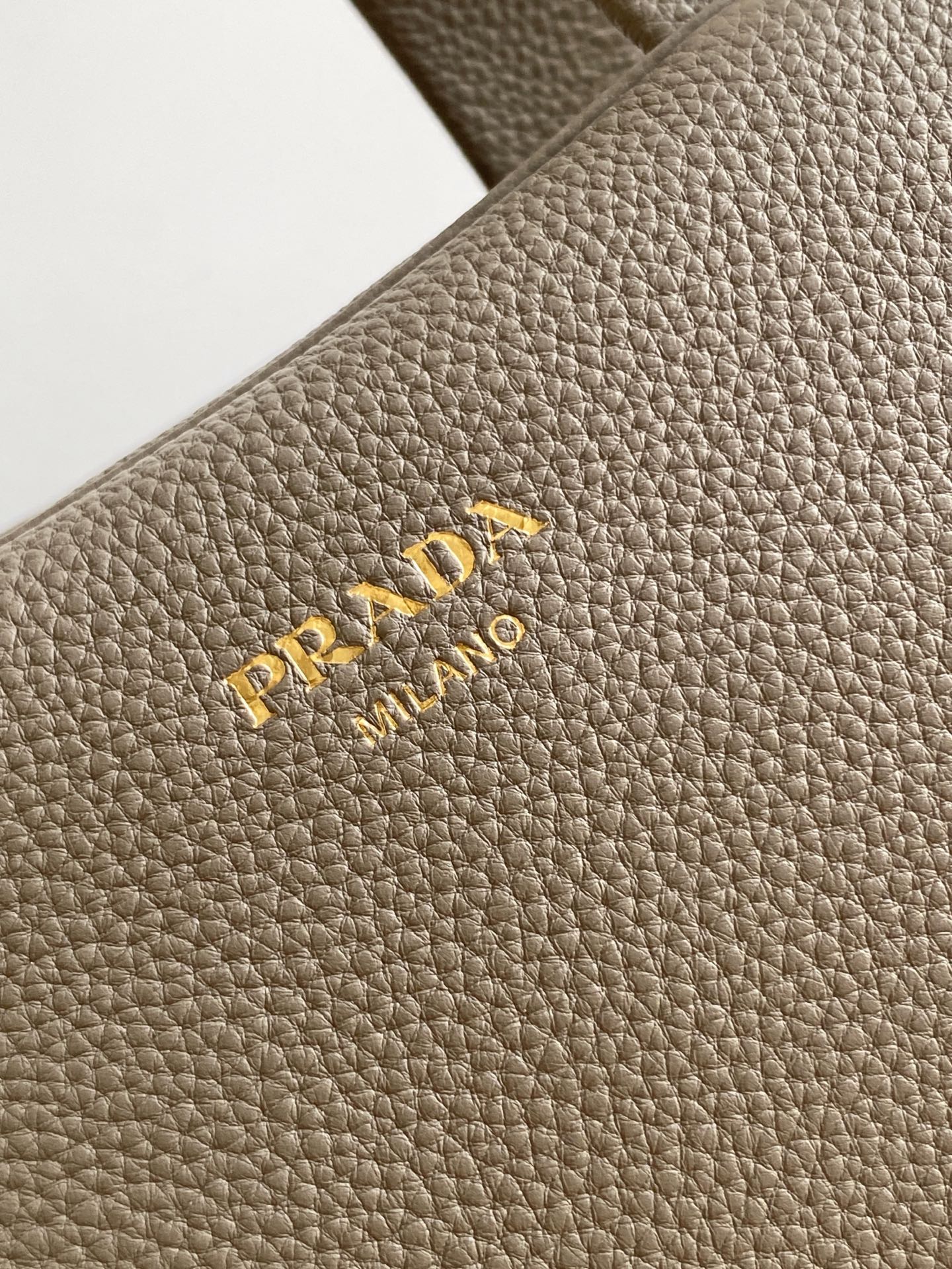 Prada 这款天然粒面皮革制成的顶部提手包袋以柔软的轮廓进行了重新诠释 可手提或搭配可拆式肩带佩戴