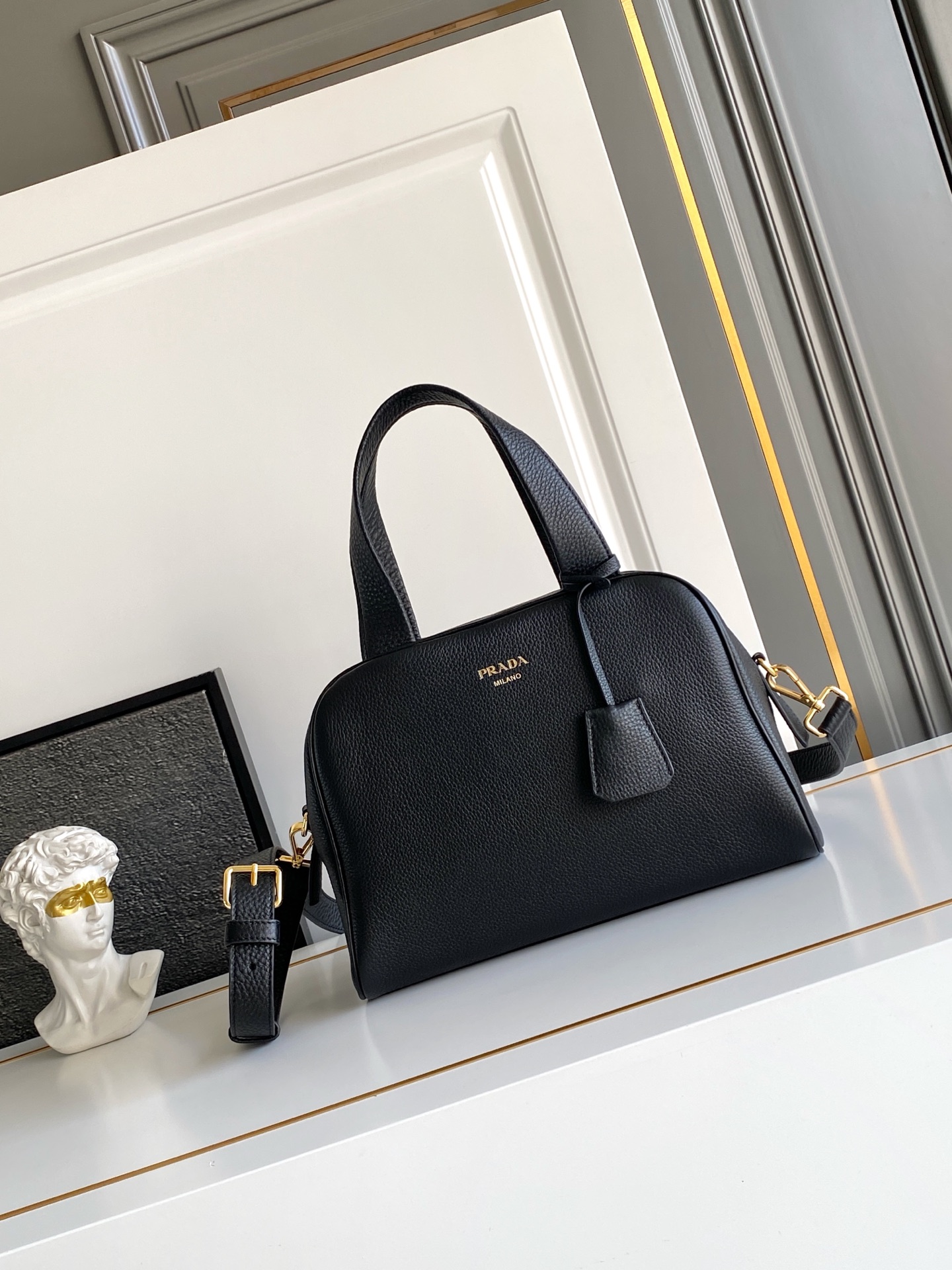 Prada 这款天然粒面皮革制成的顶部提手包袋以柔软的轮廓进行了重新诠释 可手提或搭配可拆式肩带佩戴