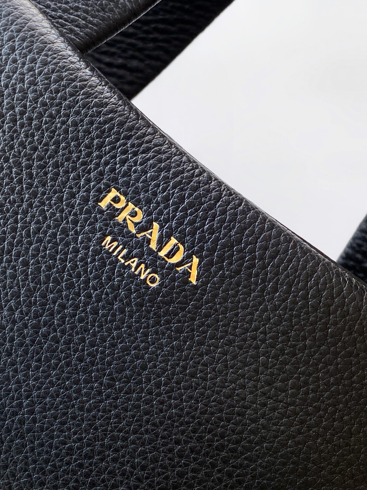 Prada 这款天然粒面皮革制成的顶部提手包袋以柔软的轮廓进行了重新诠释 可手提或搭配可拆式肩带佩戴