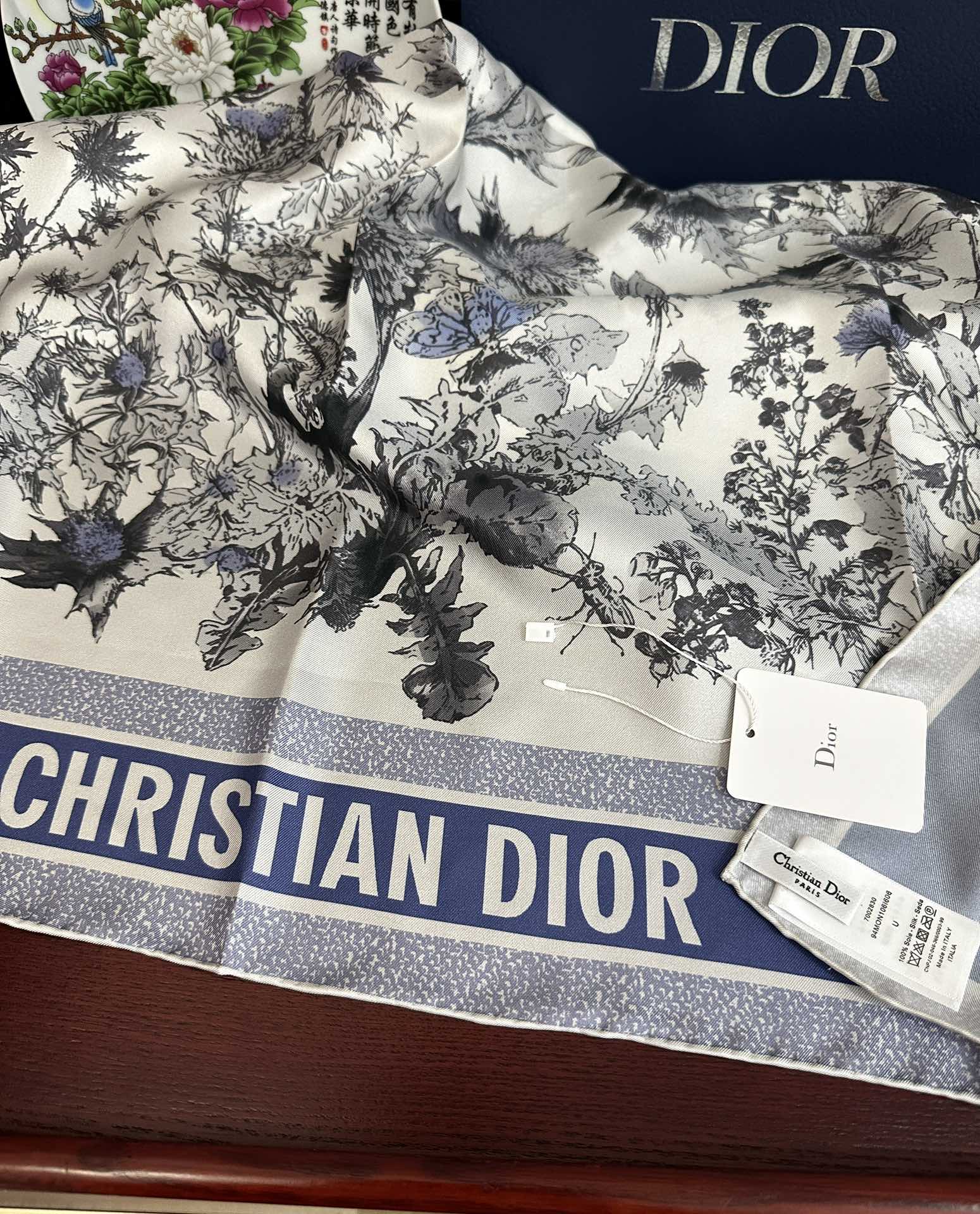Dior 高版本Dior Chardons 图案印花 展示象征着保护、韧性和自由的苏格兰国花 采用白色和蓝色桑蚕丝斜纹面料精心制作 双面设计搭配手工卷边 点缀以对比鲜明的 Christian 标志提花条形图案提升格调 可系在颈部或作为头巾使用 打造 的 造型