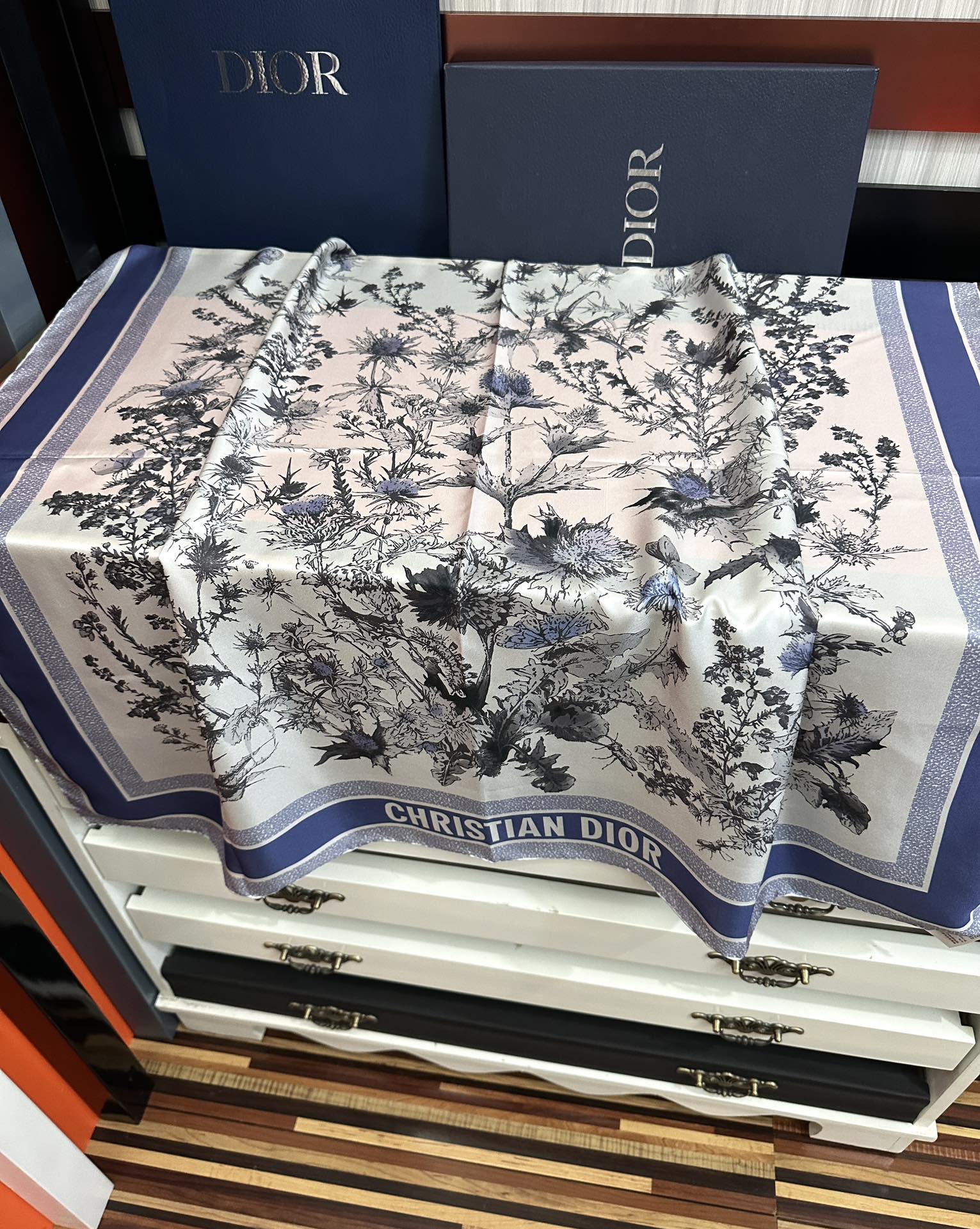 Dior 高版本Dior Chardons 图案印花 展示象征着保护、韧性和自由的苏格兰国花 采用白色和蓝色桑蚕丝斜纹面料精心制作 双面设计搭配手工卷边 点缀以对比鲜明的 Christian 标志提花条形图案提升格调 可系在颈部或作为头巾使用 打造 的 造型