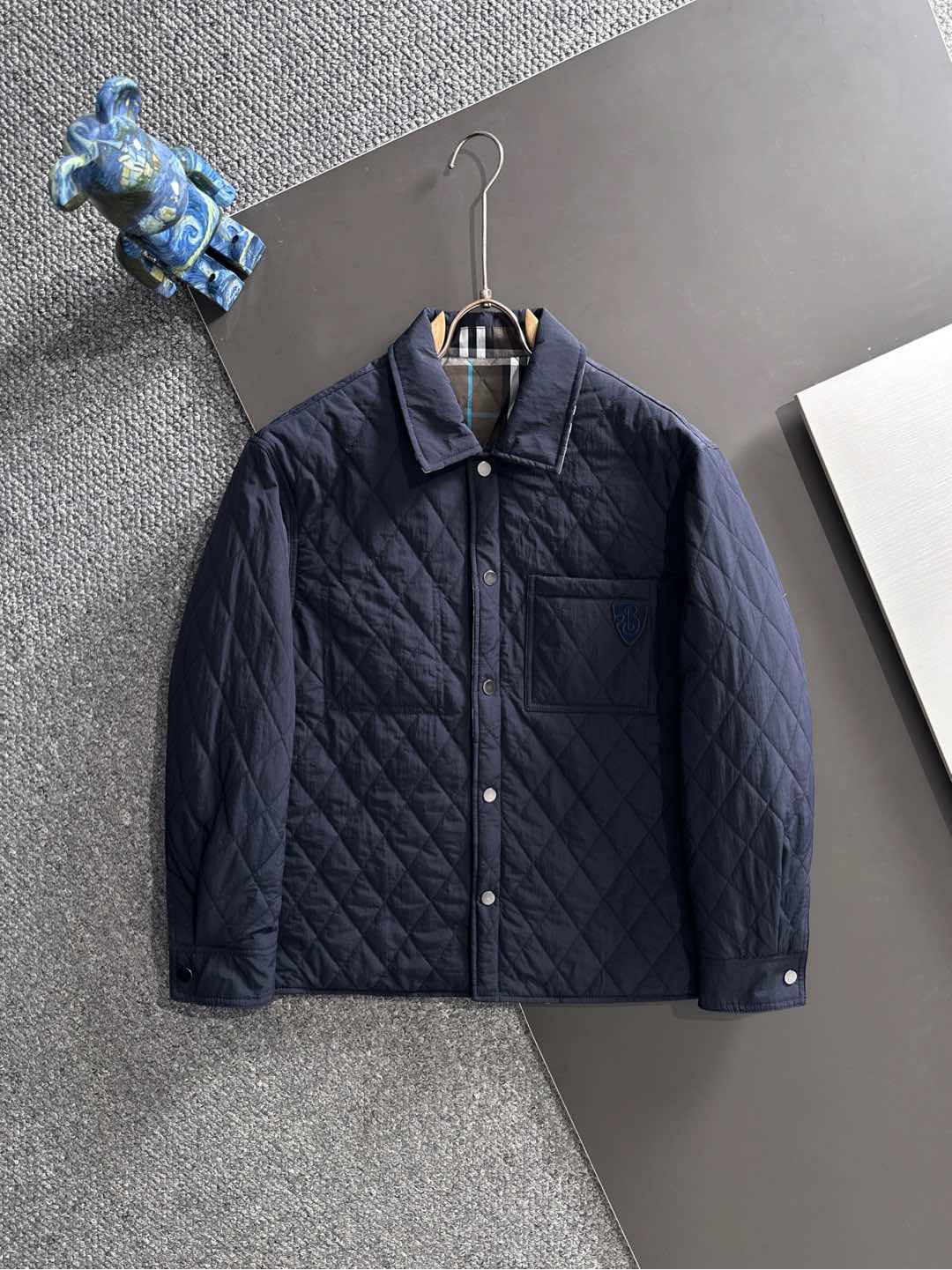 NO:629453,25 new autumn and winter styles~BBR double-sided quilted cotton jacket. This double-sided quilted jacket embodies the British luxury and warm philosophy of wearing two clothes!  One side is a solid-color nylon design, with a simple and elegant quilted diamond grid, which is low-key and exquisite; the other side is the iconic Burbe** plaid cotton twill fabric, where the classic plaid collides with blue lines, instantly awakening the memory of British fashion. The double-sided outfit is not only a cool minimalist texture, but also a retro carnival for plaid fans.  The casual fit is compatible with various styles, and the hardware buttons and exquisite embroidered logo details add a sense of quality; the padding inside brings just the right amount of warmth, allowing you to travel calmly between the streets and the workplace in the cooler weather. Reversible M-3XL,,burberry,jackets & coats,alexander wang1986090925秋冬新款~BBR双面穿绗缝棉服外套 这款双面穿绗缝外套一衣两穿的英伦奢暖哲学！ 一面是纯色尼龙设计,简约大气的绗缝菱形格,低调中透着精致；另一面则是标志性Burbe**格纹棉质斜纹面料,经典格纹与蓝调线条碰撞,瞬间唤醒英伦时尚记忆.双面穿搭,既是极简主义的清冷质感,也是格纹拥趸的复古狂欢. 休闲版型兼容各种风格,五金纽扣与精致刺绣徽标细节拉满品质感；内里填充带来恰到好处的暖意,让你在微凉时节从容穿梭于街头与职场. 双面穿 M-3XL,,burberry,jackets & coats,alexander wang,Men's clothing