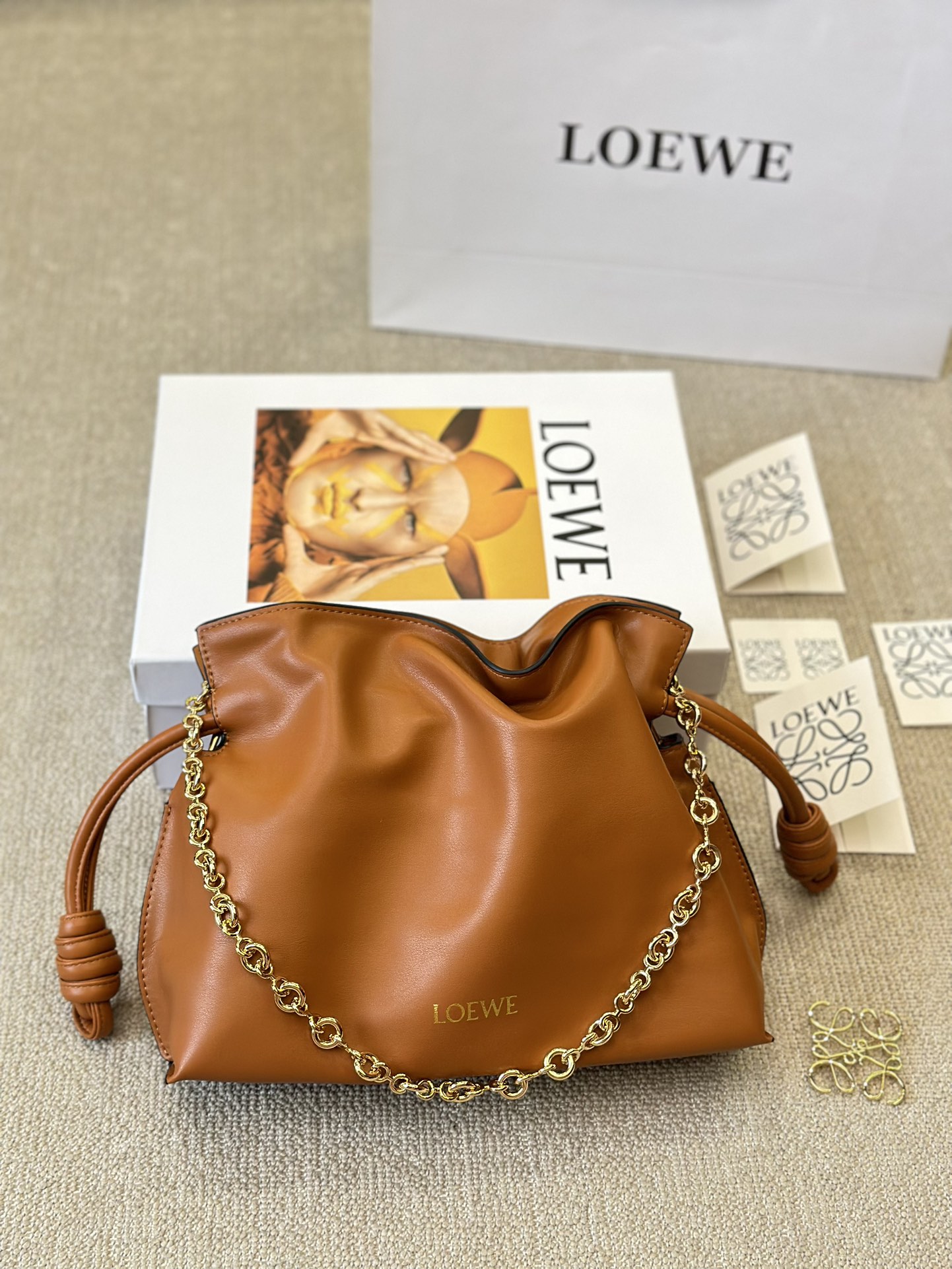 牛皮版本 p210
Loewe 迷你羊皮 purse 福袋 
Loewe 兴 迷你柔软纳帕羊皮革 Flamenco Purse 福袋
采用褶皱设计，侧面搭配标志性绳结等关键细节。款式
时尚百搭，可作为手拿包携带，亦可搭配甜甜圈链条肩背，或搭配皮革肩带斜挎。此版本采用柔软纳帕羊皮革制成。可肩背、斜挎或手提*可拆卸可调节皮革肩带*可
拆卸甜甜圈链条饰*Anagram 镌刻卵石纹*低调的磁扣开
合*绒面革衬里烫金或烫银*(配套金屬鏈條加长皮肩帶）尺寸30 25cm