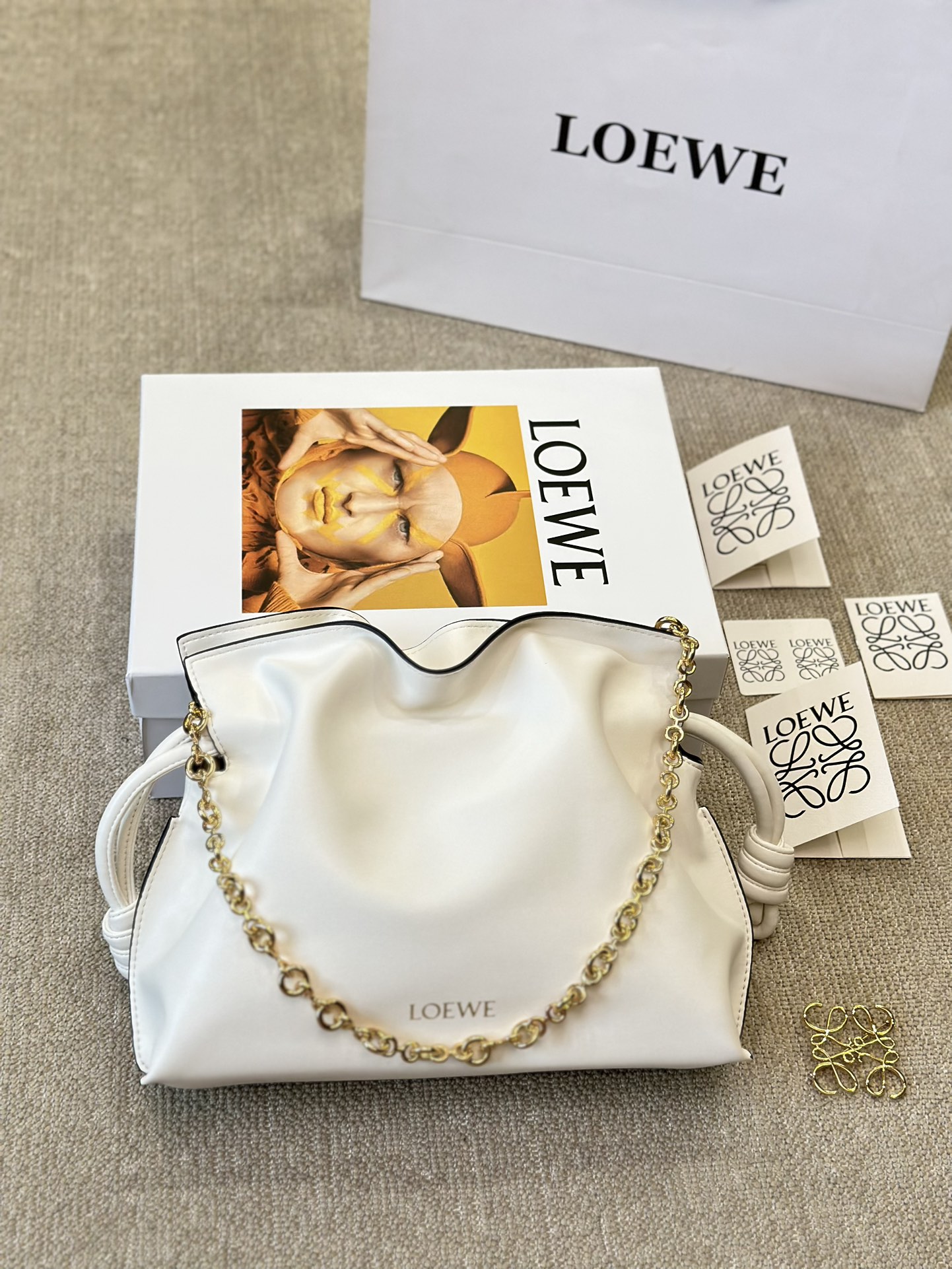 牛皮版本 p210
Loewe 迷你羊皮 purse 福袋 
Loewe 兴 迷你柔软纳帕羊皮革 Flamenco Purse 福袋
采用褶皱设计，侧面搭配标志性绳结等关键细节。款式
时尚百搭，可作为手拿包携带，亦可搭配甜甜圈链条肩背，或搭配皮革肩带斜挎。此版本采用柔软纳帕羊皮革制成。可肩背、斜挎或手提*可拆卸可调节皮革肩带*可
拆卸甜甜圈链条饰*Anagram 镌刻卵石纹*低调的磁扣开
合*绒面革衬里烫金或烫银*(配套金屬鏈條加长皮肩帶）尺寸30 25cm