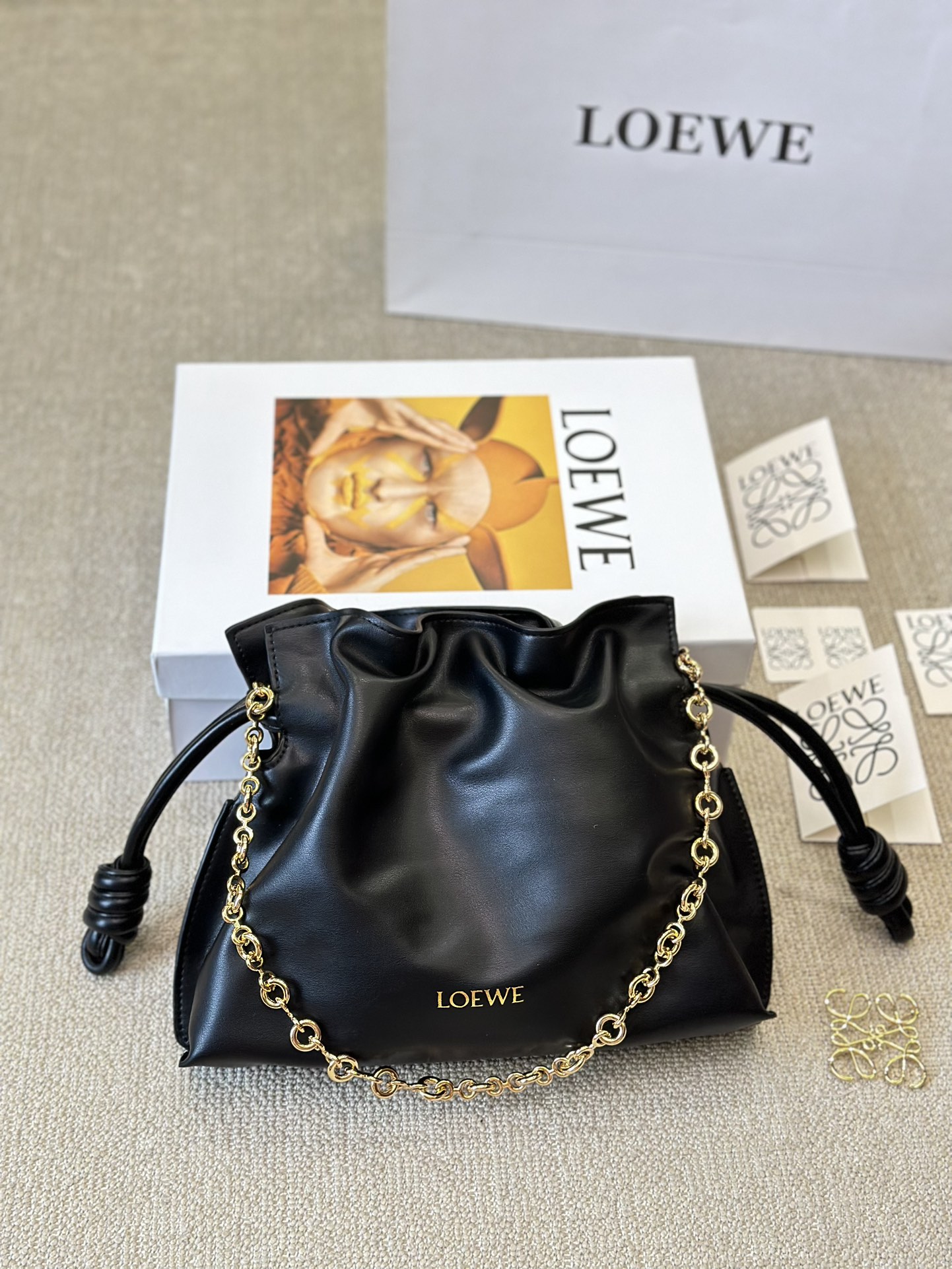 牛皮版本 p210
Loewe 迷你羊皮 purse 福袋 
Loewe 兴 迷你柔软纳帕羊皮革 Flamenco Purse 福袋
采用褶皱设计，侧面搭配标志性绳结等关键细节。款式
时尚百搭，可作为手拿包携带，亦可搭配甜甜圈链条肩背，或搭配皮革肩带斜挎。此版本采用柔软纳帕羊皮革制成。可肩背、斜挎或手提*可拆卸可调节皮革肩带*可
拆卸甜甜圈链条饰*Anagram 镌刻卵石纹*低调的磁扣开
合*绒面革衬里烫金或烫银*(配套金屬鏈條加长皮肩帶）尺寸30 25cm