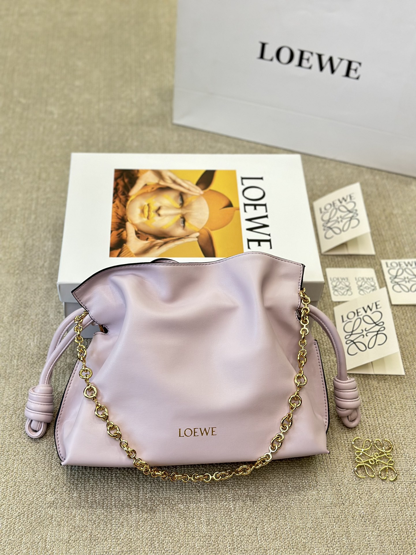 牛皮版本 p210
Loewe 迷你羊皮 purse 福袋 
Loewe 兴 迷你柔软纳帕羊皮革 Flamenco Purse 福袋
采用褶皱设计，侧面搭配标志性绳结等关键细节。款式
时尚百搭，可作为手拿包携带，亦可搭配甜甜圈链条肩背，或搭配皮革肩带斜挎。此版本采用柔软纳帕羊皮革制成。可肩背、斜挎或手提*可拆卸可调节皮革肩带*可
拆卸甜甜圈链条饰*Anagram 镌刻卵石纹*低调的磁扣开
合*绒面革衬里烫金或烫银*(配套金屬鏈條加长皮肩帶）尺寸30 25cm
