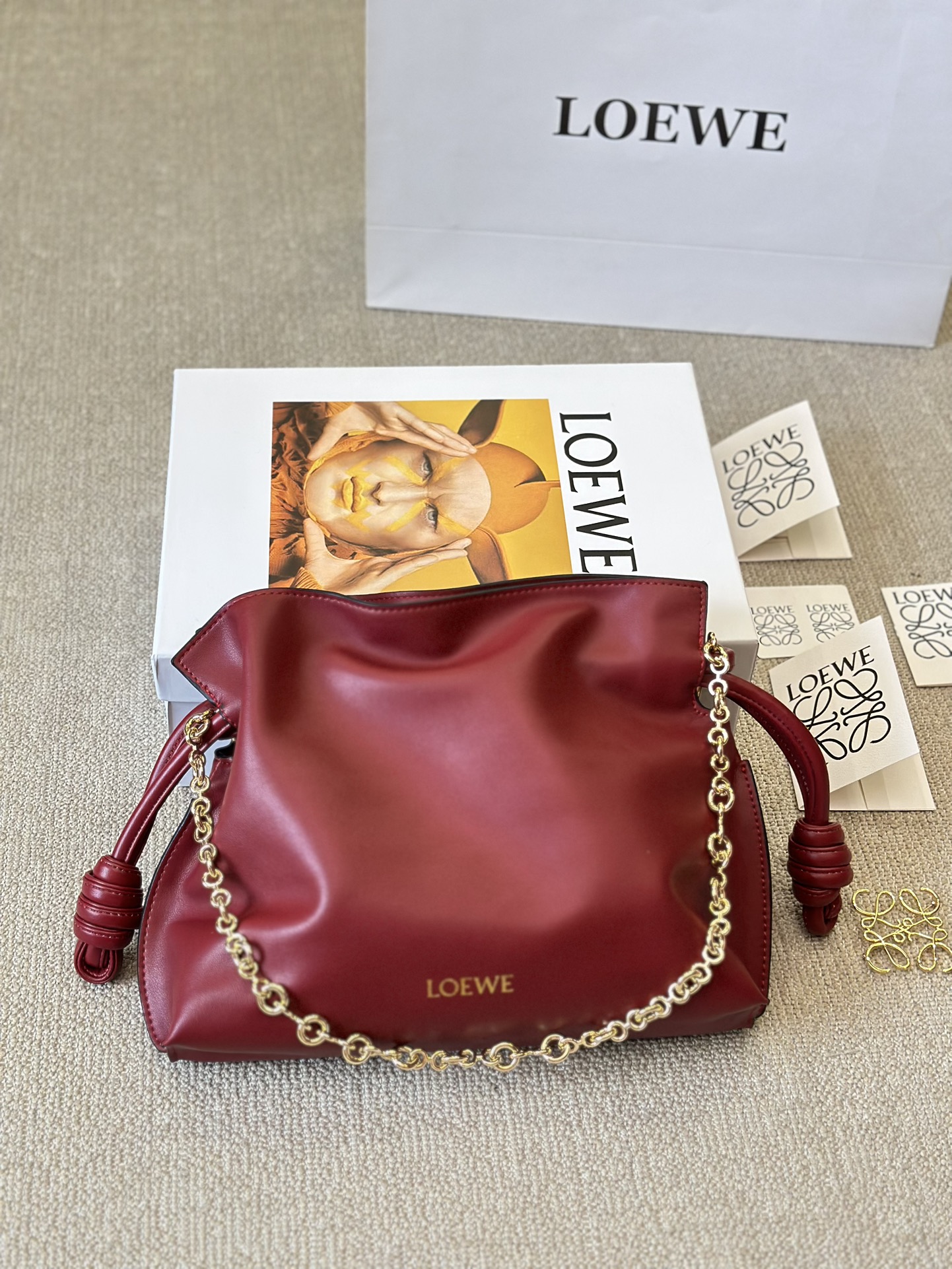 牛皮版本 p210
Loewe 迷你羊皮 purse 福袋 
Loewe 兴 迷你柔软纳帕羊皮革 Flamenco Purse 福袋
采用褶皱设计，侧面搭配标志性绳结等关键细节。款式
时尚百搭，可作为手拿包携带，亦可搭配甜甜圈链条肩背，或搭配皮革肩带斜挎。此版本采用柔软纳帕羊皮革制成。可肩背、斜挎或手提*可拆卸可调节皮革肩带*可
拆卸甜甜圈链条饰*Anagram 镌刻卵石纹*低调的磁扣开
合*绒面革衬里烫金或烫银*(配套金屬鏈條加长皮肩帶）尺寸30 25cm