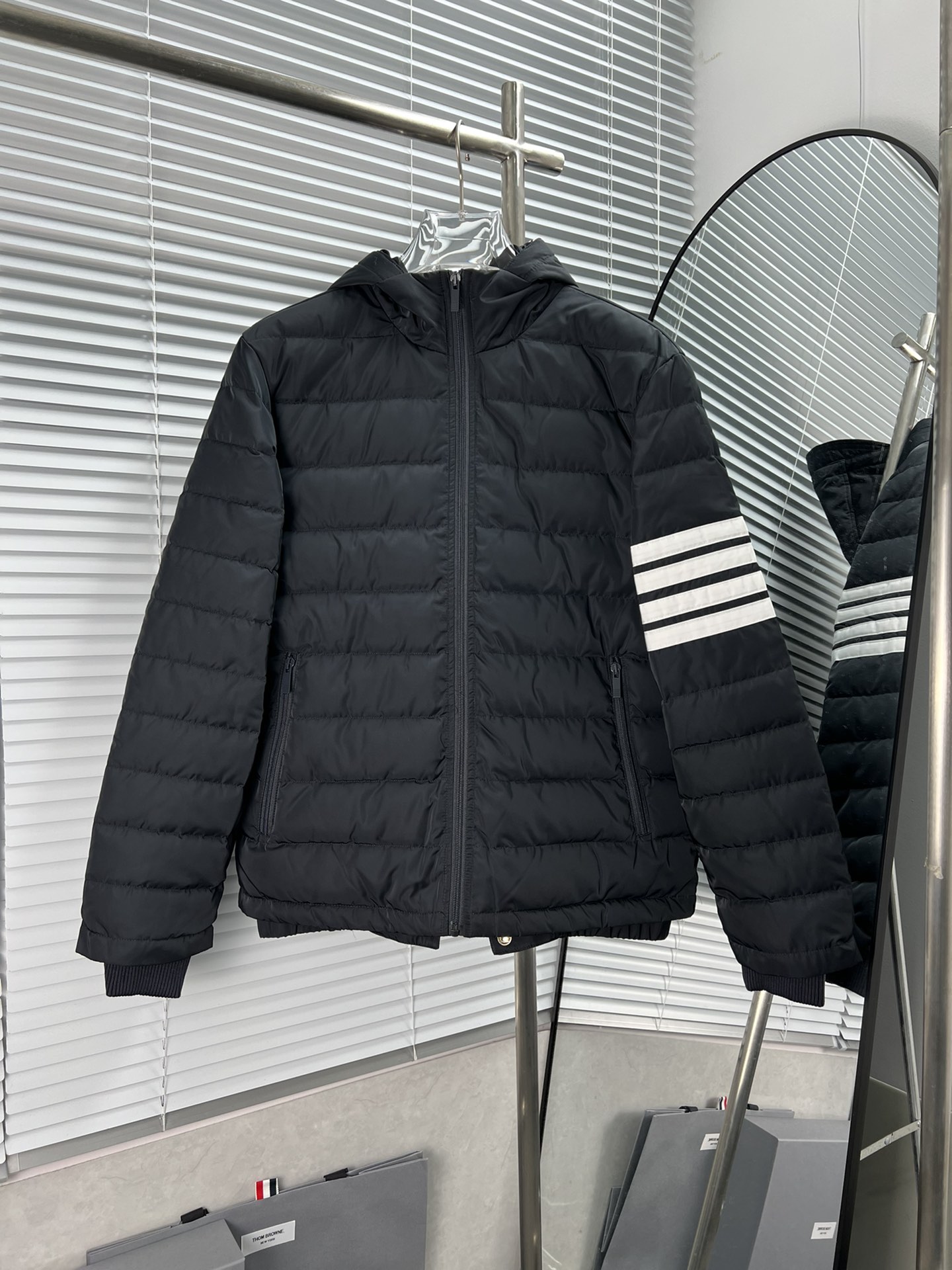 Nueva chaqueta plumífera con capucha y cuatro rayas clásicas de Thom Browne, material 100% nailon con acabado mate, rel…