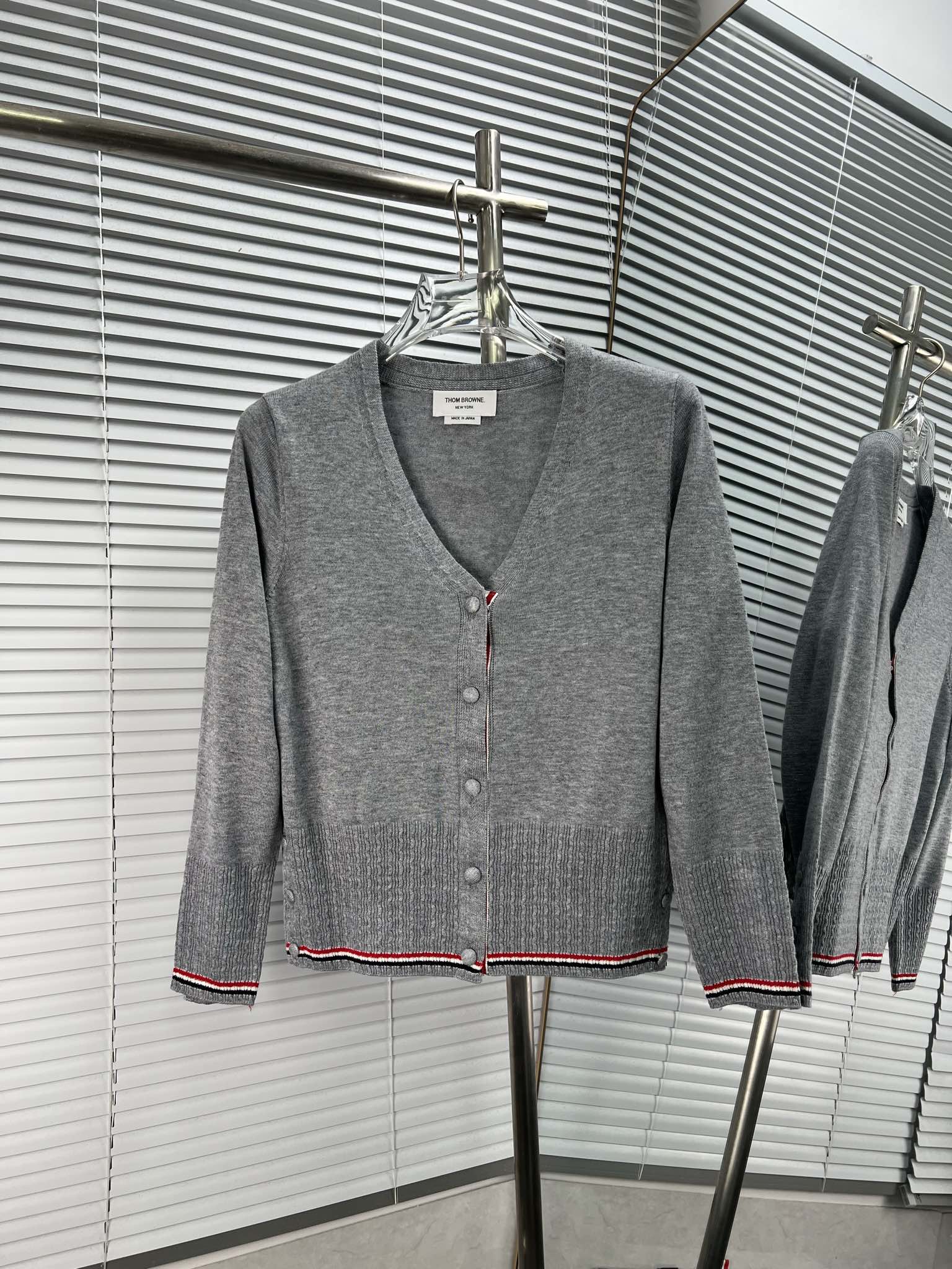 Cárdigan de punto de manga larga de THOM BROWNE con diseño de botones de trenza rojo, blanco y azul en el dobladillo, e…