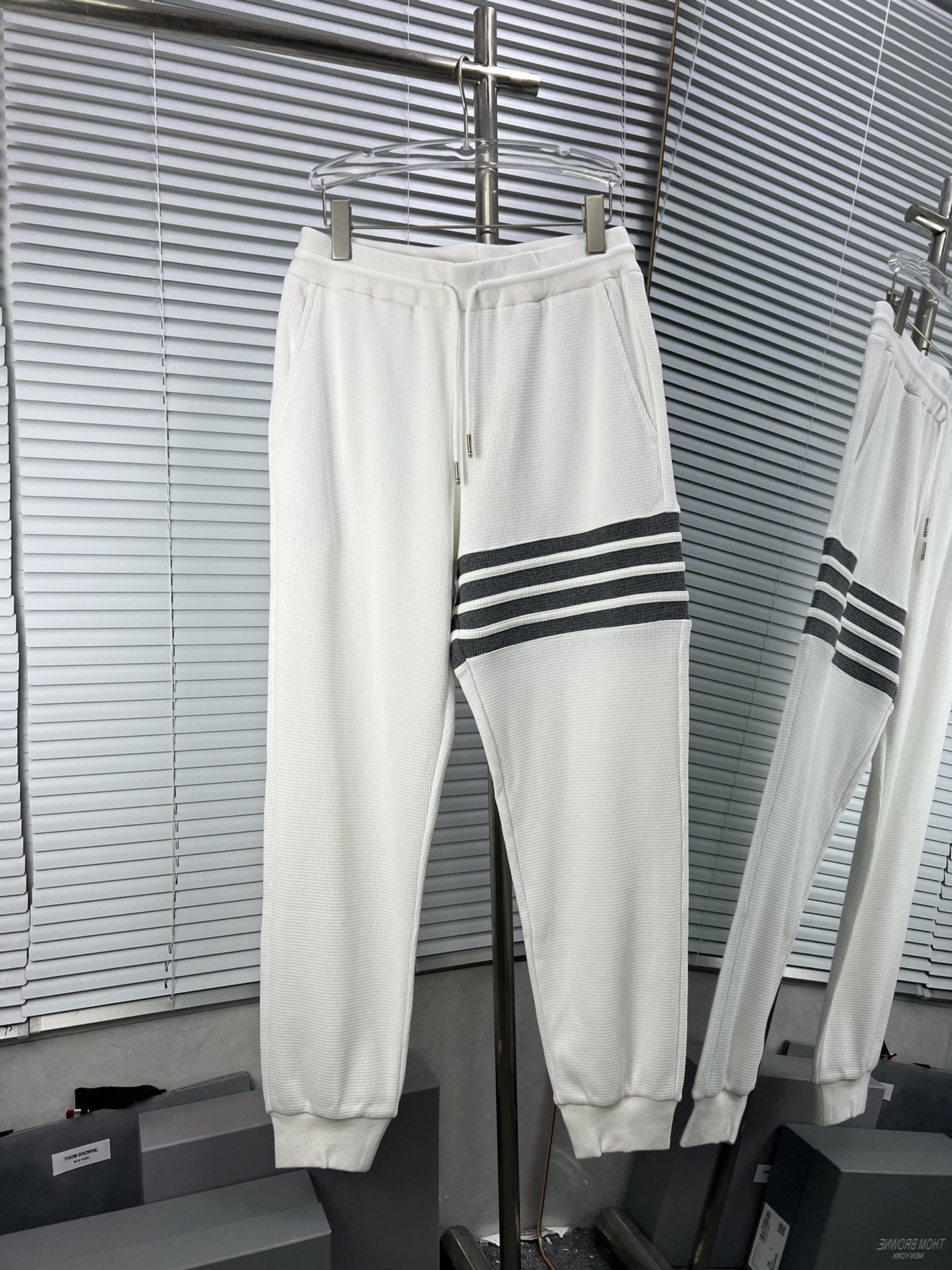 Pantalones de chándal Thom Browne de gofre con cuatro barras verticales. Todo el pantalón utiliza tela de hil…