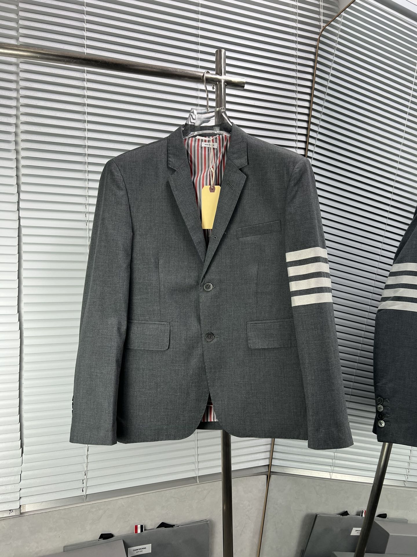 THOM BROWNE traje blanco con cuatro rayas tejidas. Hereda el clásico diseño de cuatro rayas de TB, resaltando…