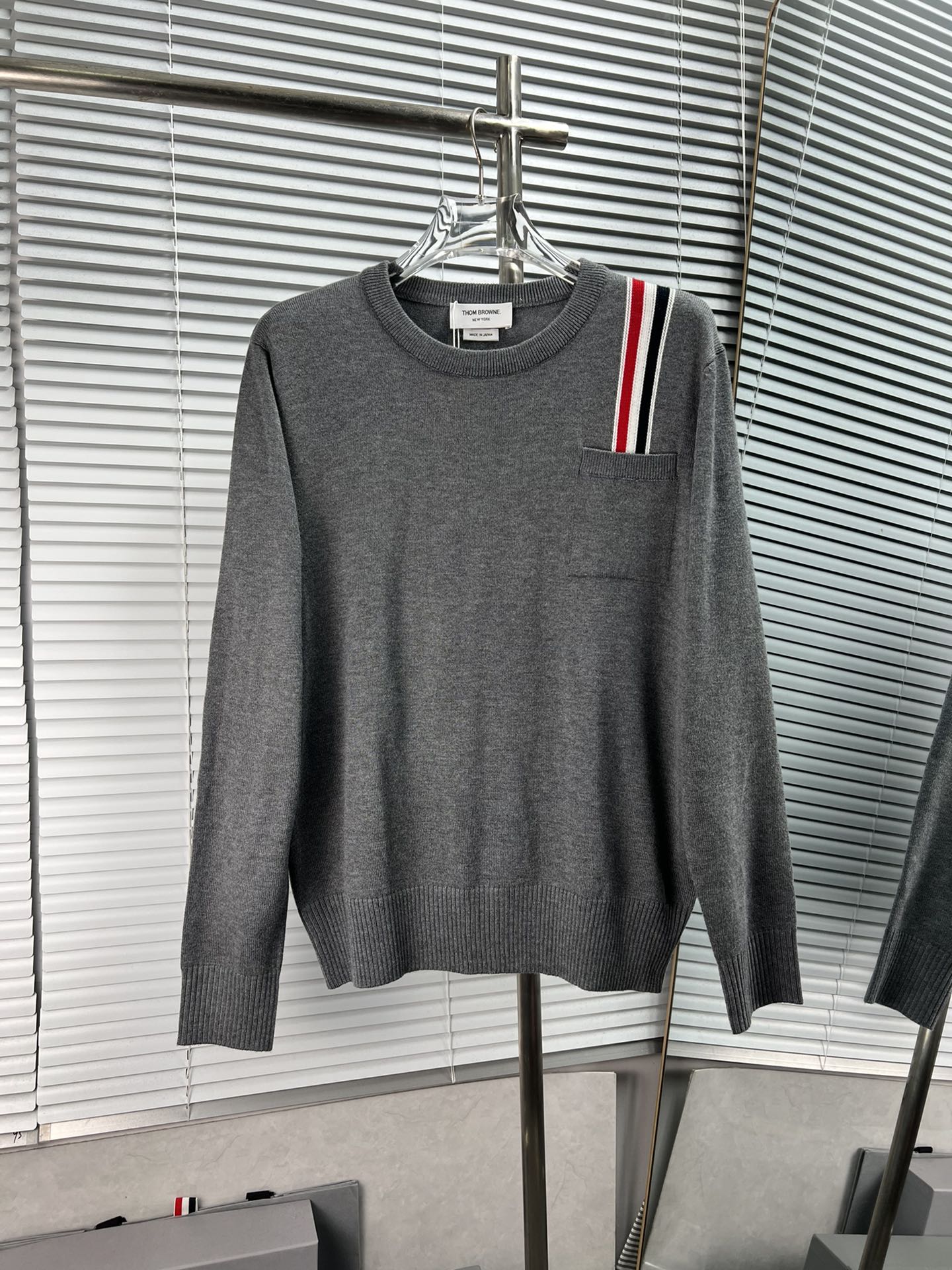THOM BROWNE Suéter de cuello redondo de lana con bolsillo y rayas verticales rojo, blanco y azul. Colores: gris, azul. …