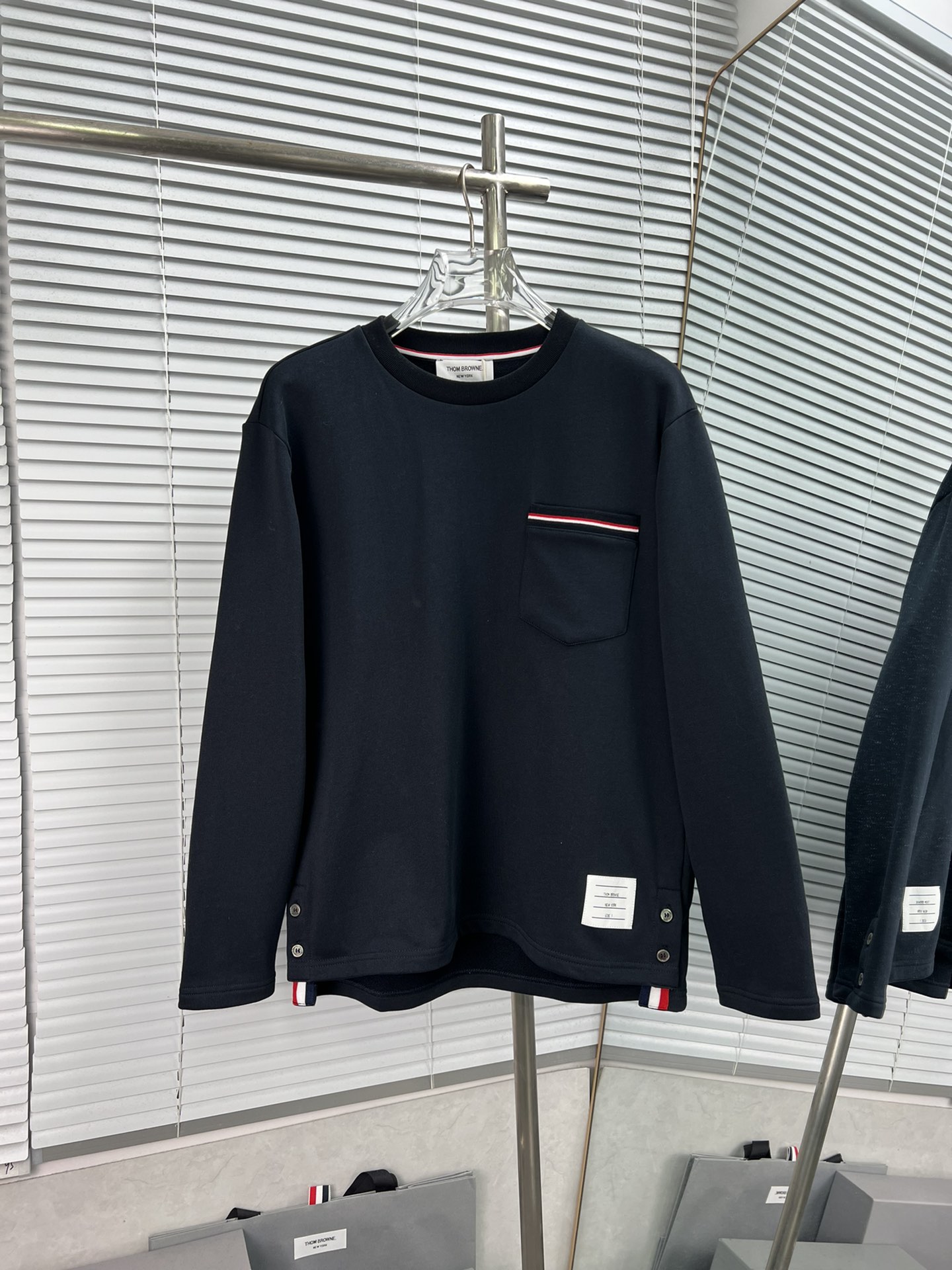 Thom Browne TB Sudadera clásica de cuello redondo con bolsillo. Hereda el corte atrevido de TB y la nueva tecnología de…