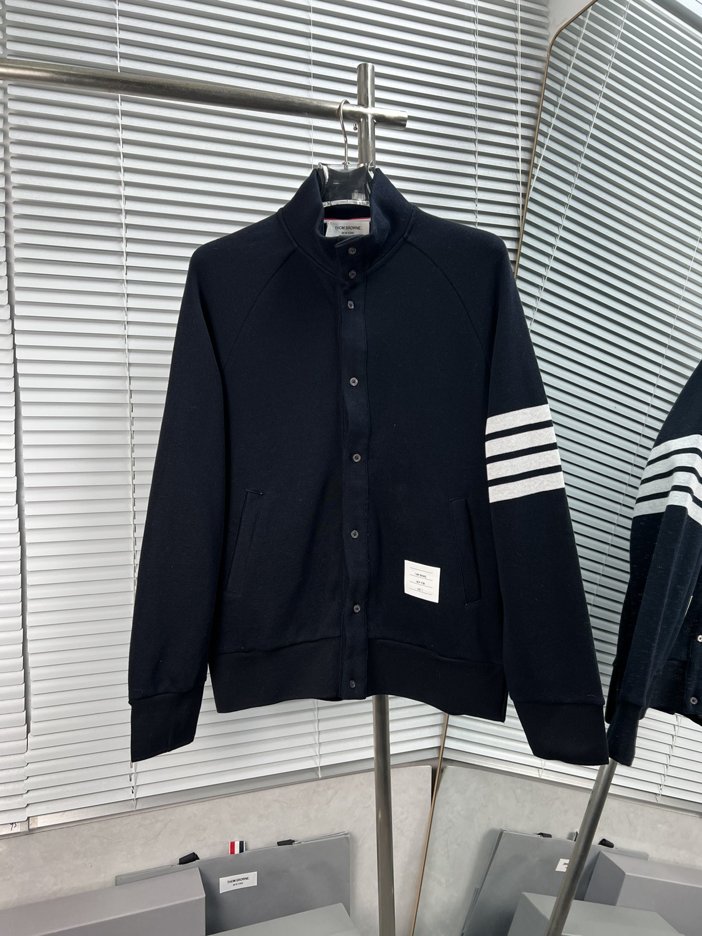 ¡Chaqueta de cuello alto con botones y cuatro rayas blancas de THOM BROWNE, nuevo modelo! Con tejido afelpado original,…