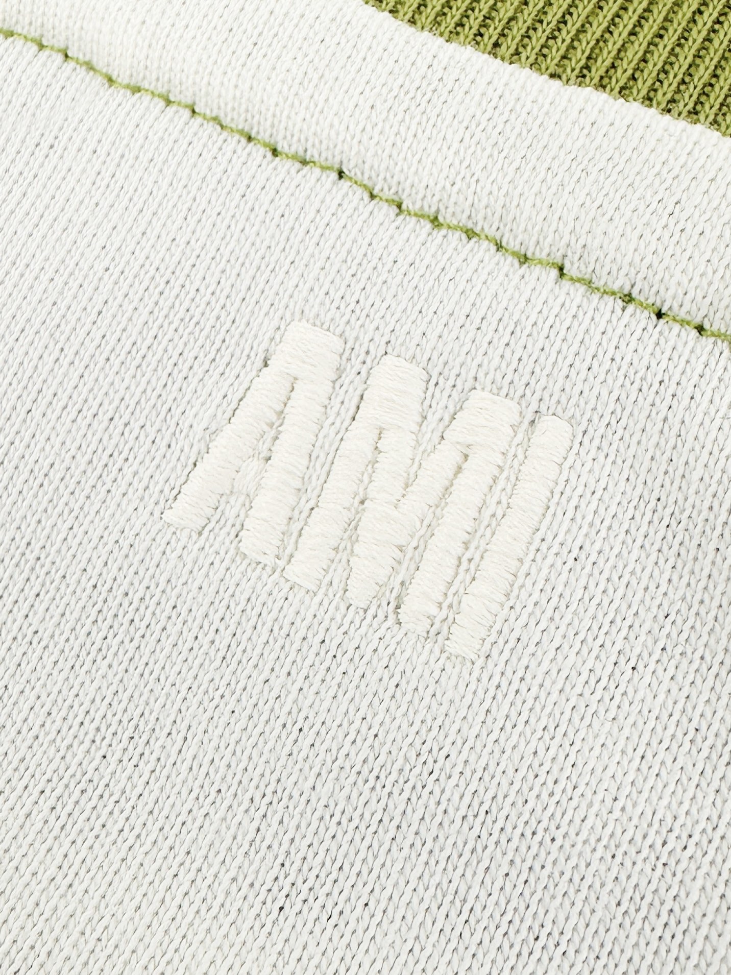 Ami Paris 定制精梳柔密棉 细腻柔软 舒适贴肤 奶杏白底色温润治愈 柔光敛藏温柔 橄榄绿插肩袖撞色拼接 鲜活元气 唤醒春日氛围 胸前钩织爱心徽标悄然绽放 细腻肌理交织奢华触感 Ami字母刺绣隐缀后领 精工针脚 藏而不露的高级 将法式浪漫与春日清新感 凝于方寸之间