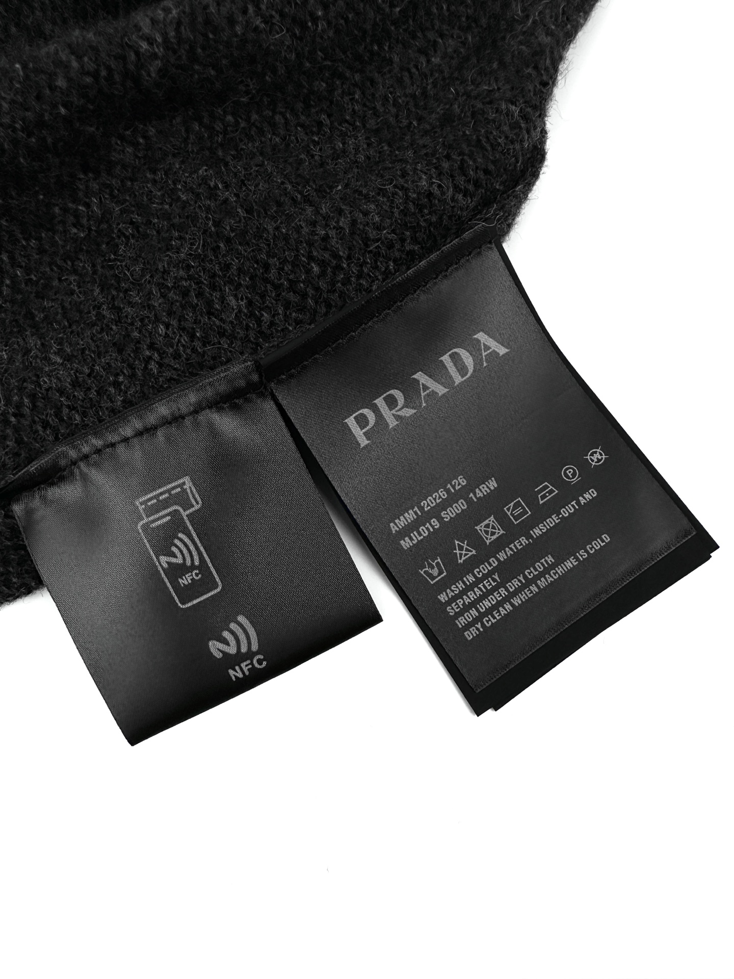 Prada 工艺1: 手摇专机浮雕花型工艺 通过匠人手工操控定制化专用编织机 人机协同的编织逻辑 实时调整纱线张力 控制织针起落 形成具有立体凹凸肌理的Prada三角徽标