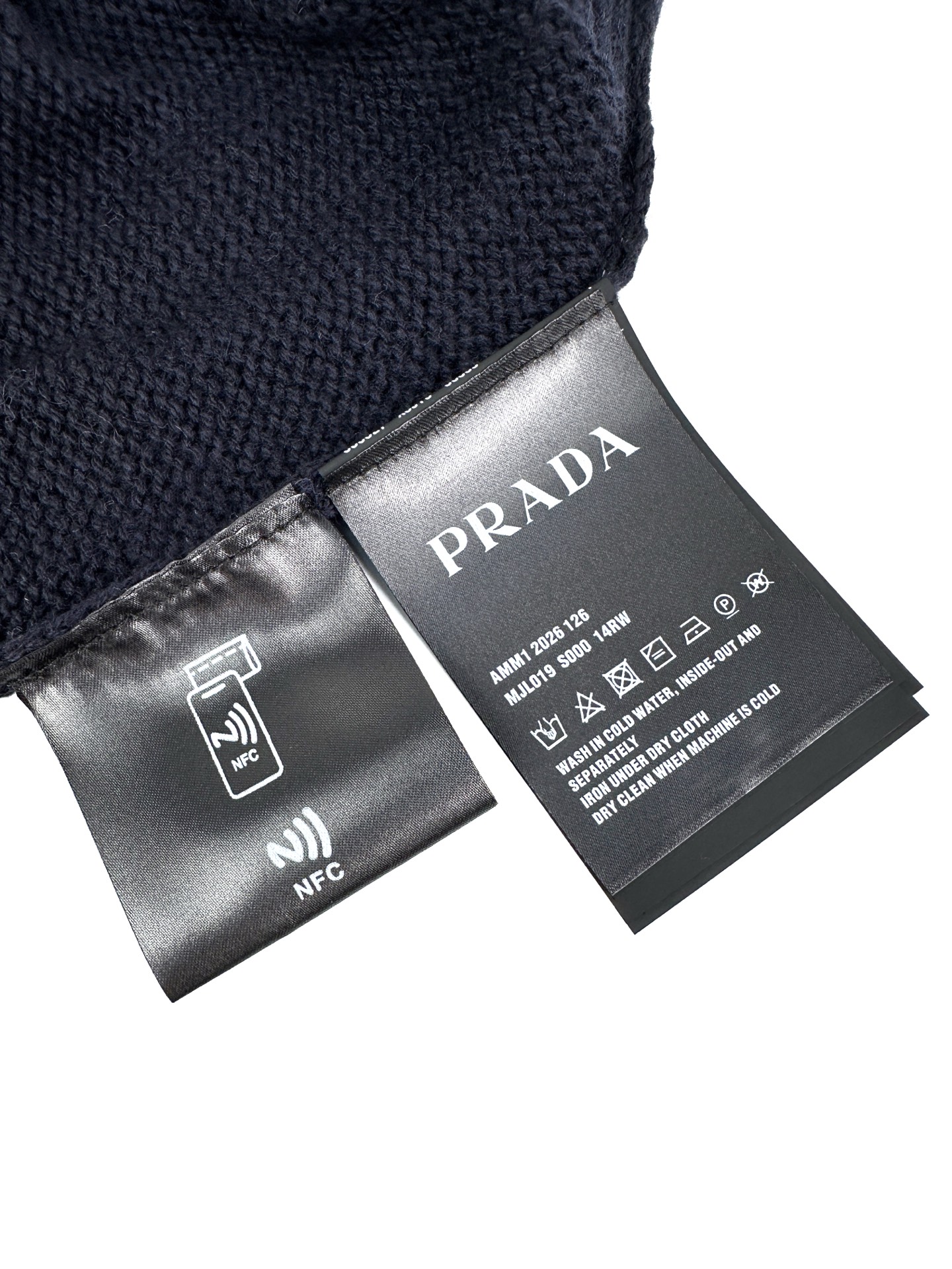 Prada 工艺1: 手摇专机浮雕花型工艺 通过匠人手工操控定制化专用编织机 人机协同的编织逻辑 实时调整纱线张力 控制织针起落 形成具有立体凹凸肌理的Prada三角徽标