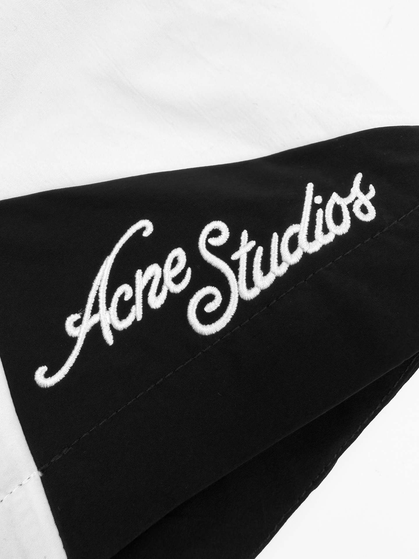 Acne Studios 定制柔雾科技棉混纺 轻盈垂坠 柔雾亲肤 雾面黑调沉淀斯堪的纳维亚式克制美学 两侧几何撞色拼片 与后腰利落滚边 解构 轮廓 如北欧冬夜的星芒切割出利落秩序 手写体Acne Studios徽标轻缀于下摆 是无需张扬的品牌署名 侧袋和后拉链口袋暗藏实用匠心 让舒适与极简奢雅 在行走中悄然共生