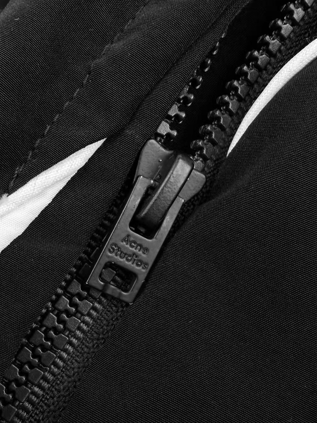 Acne Studios 定制柔雾科技棉混纺 轻盈垂坠 柔雾亲肤 雾面黑调沉淀斯堪的纳维亚式克制美学 两侧几何撞色拼片 与后腰利落滚边 解构 轮廓 如北欧冬夜的星芒切割出利落秩序 手写体Acne Studios徽标轻缀于下摆 是无需张扬的品牌署名 侧袋和后拉链口袋暗藏实用匠心 让舒适与极简奢雅 在行走中悄然共生