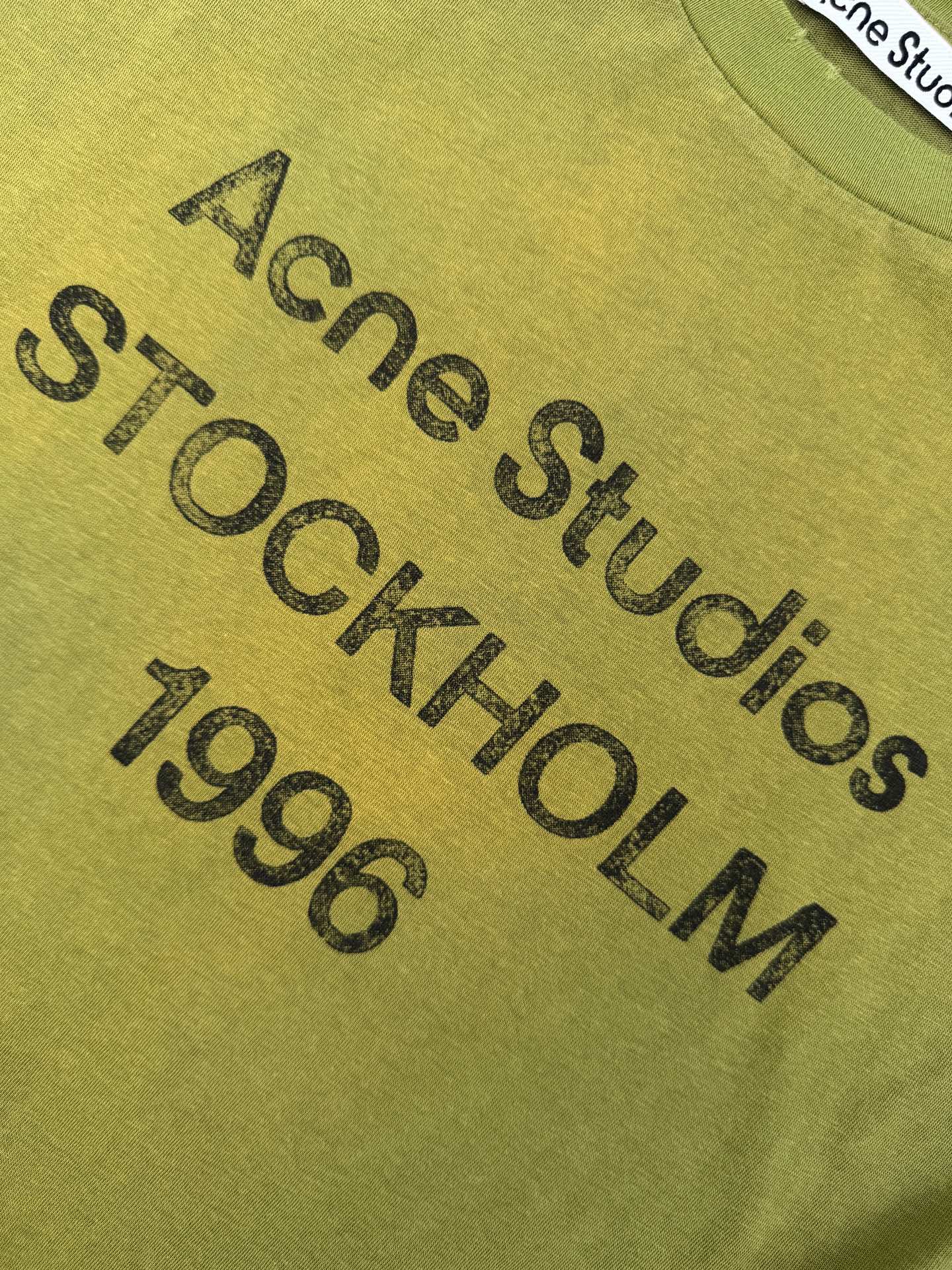 Acne Studios 定制云绒爽滑雪感棉 垂感爽滑 细腻透气 一抹苔原浅绿悄然绽放 松弛疏离 奢感自生 Acne Studios 1996徽标图案点缀于胸前 字母笔触的深浅不均 宛如岁月镌刻的印记 加以喷绘做旧的不完美感为升华 形成柔与刚的视觉碰撞 无需多言 设计自会说话 让衣服成为穿者个性的延伸