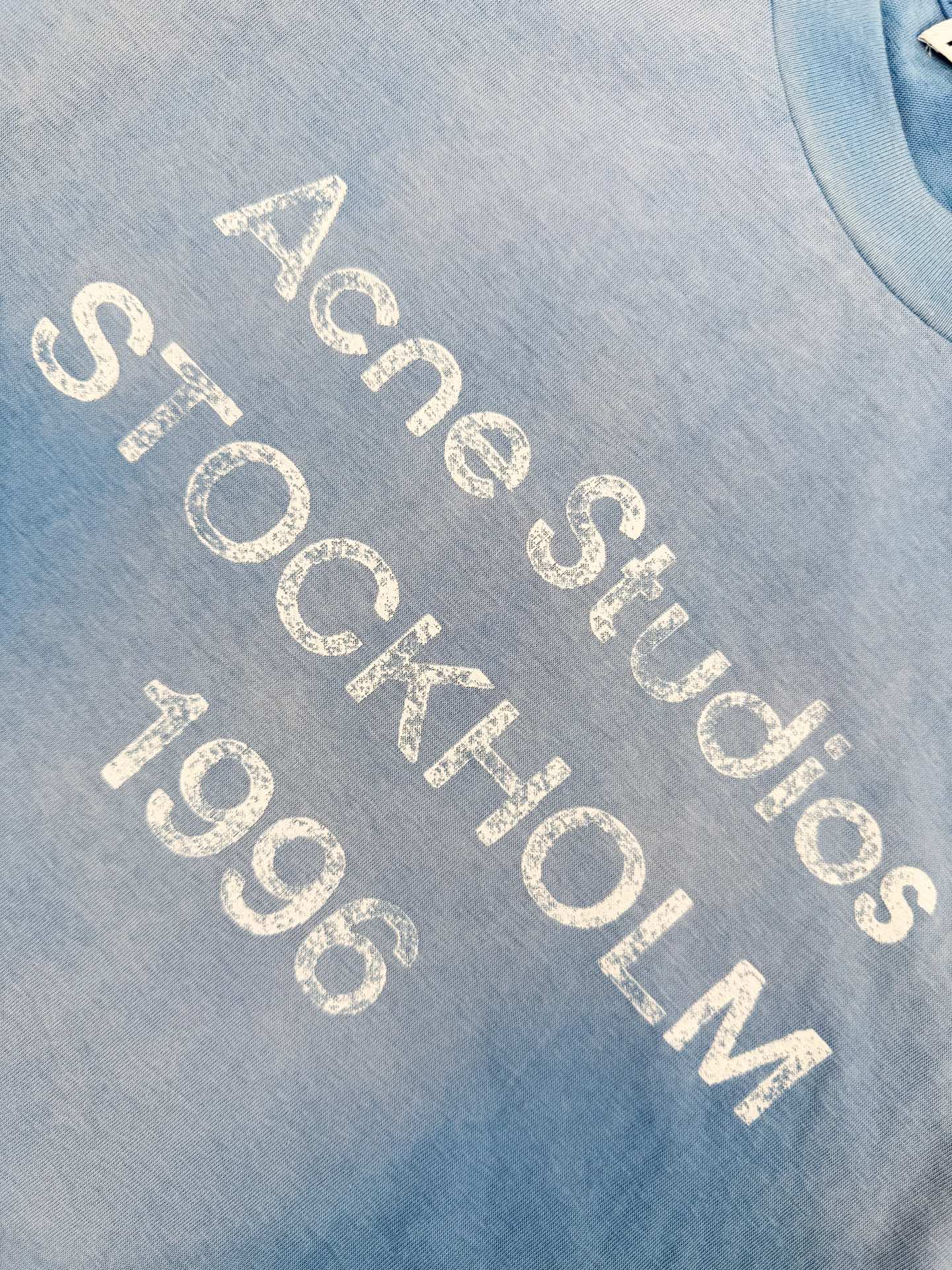 Acne Studios 定制云绒爽滑雪感棉 垂感爽滑 细腻透气 一抹冰川蓝悄然绽放 松弛疏离 奢感自生 Acne Studios 1996徽标图案点缀于胸前 字母笔触的深浅不均 宛如岁月镌刻的印记 加以喷绘做旧的不完美感为升华 形成柔与刚的视觉碰撞 无需多言 设计自会说话 让衣服成为穿者个性的延伸