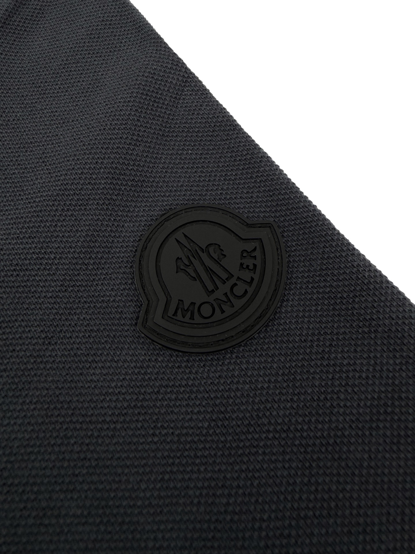 Moncler 定制双珠肌理奢棉 紧致细腻 舒适贴肤 以暗夜炭灰为底 于沉静中藏住锋芒 胸前错位叠印MONCLER字母印花 以黑白层次勾勒先锋格调 袖侧同色徽标 于暗纹肌理间镌刻身份密码 双标识静默共鸣 利落剪裁塑精英风骨 细节藏不动声色奢雅