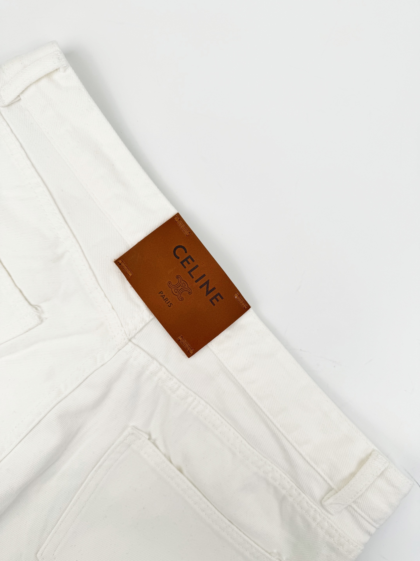 Celine 定制高密定织本白丹宁布 质感卓越 舒适贴肤 以温润柔和的奶感白调为基调 醇厚干净 一枚Celine皮牌于后腰留白处悄然点缀格调 低调显贵 以纯粹净白为设计内核 简约却极具辨识度 自带清冷松弛的老钱氛围感 行走间自有一番随性自在的气度